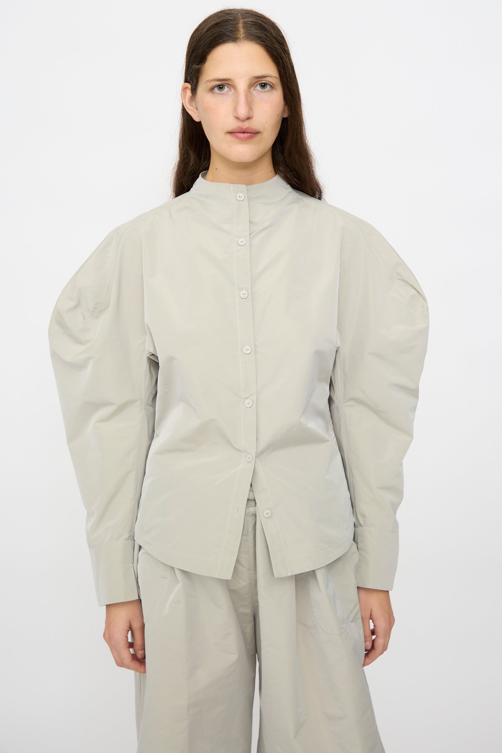 A person wears the Veronique Leroy Top with Scarf in Sage, featuring balloon sleeves, paired with matching wide-leg pants against a plain white background.