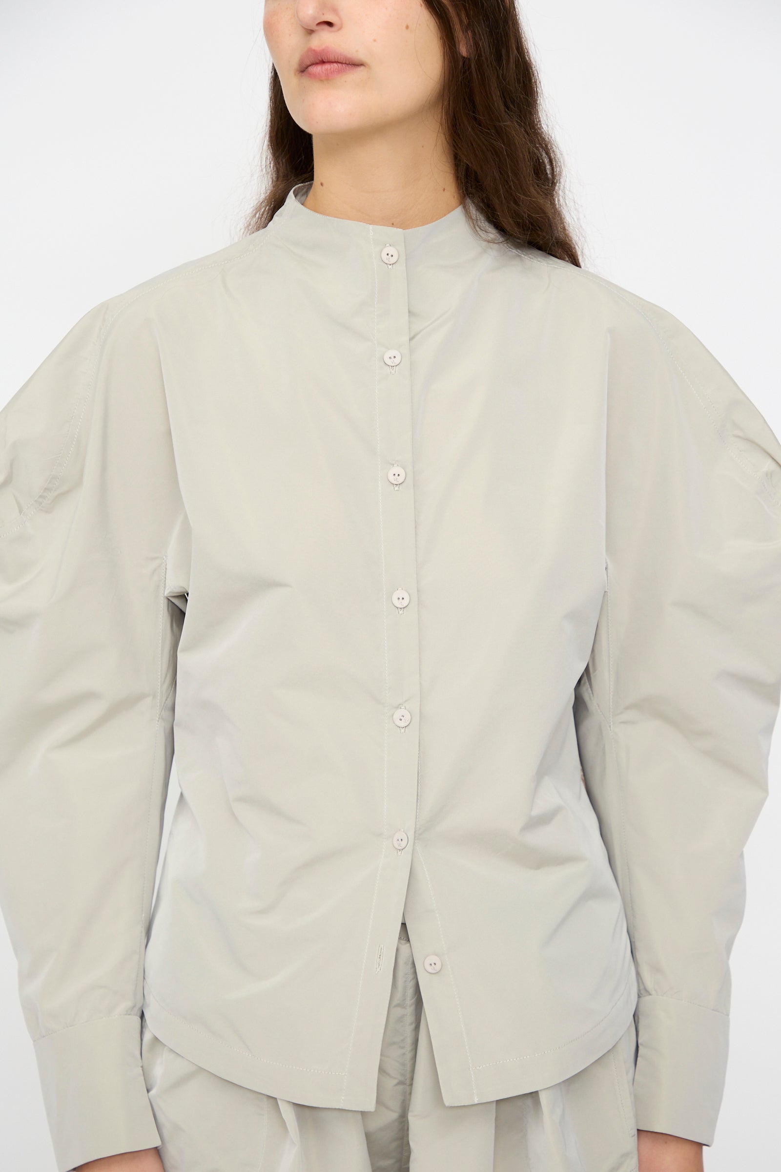 A model wears the Veronique Leroy Top with Scarf in Sage—shown from shoulders to mid-thigh—featuring balloon sleeves and a band collar, paired with matching pants.