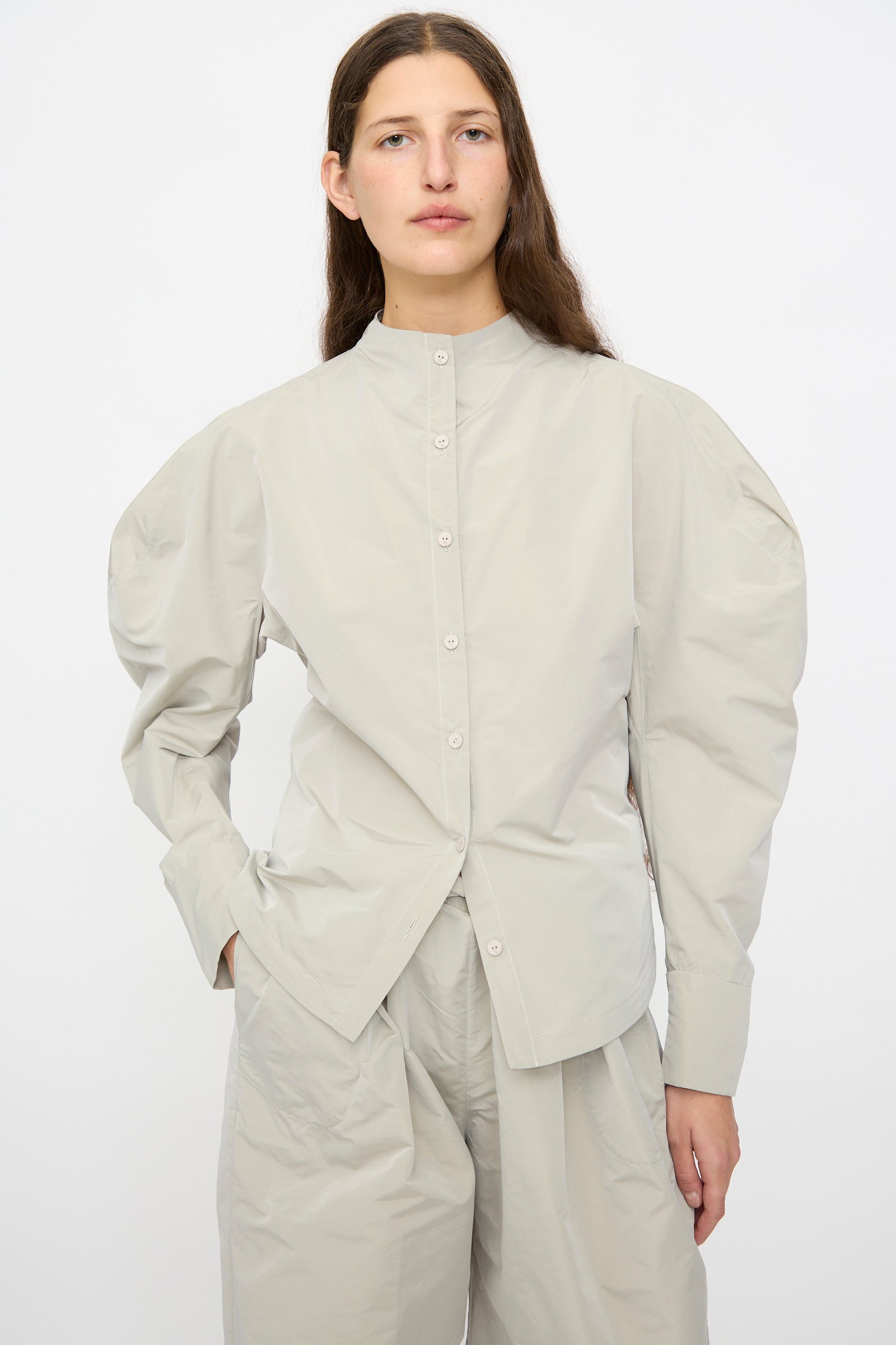 A person wears the Veronique Leroy Top with Scarf in Sage, featuring long balloon sleeves, paired with matching pants, set against a plain white background.