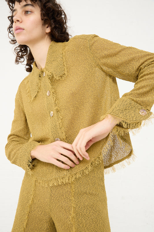 A woman with curly hair wearing a Tweed Blouse in Cumin by Veronique Leroy.