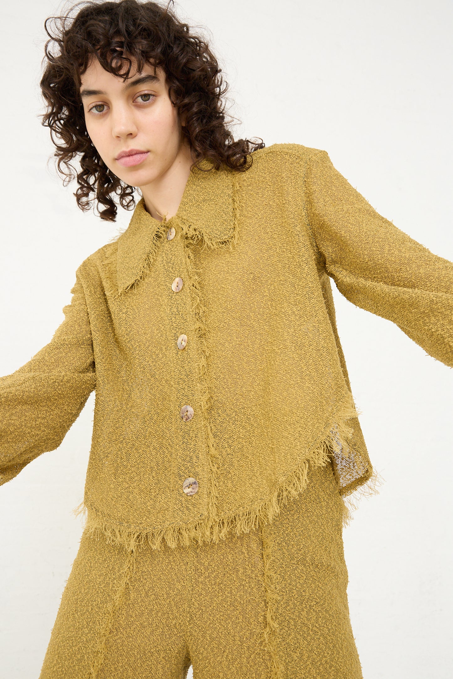 The model is wearing a Tweed Blouse in Cumin from Veronique Leroy.