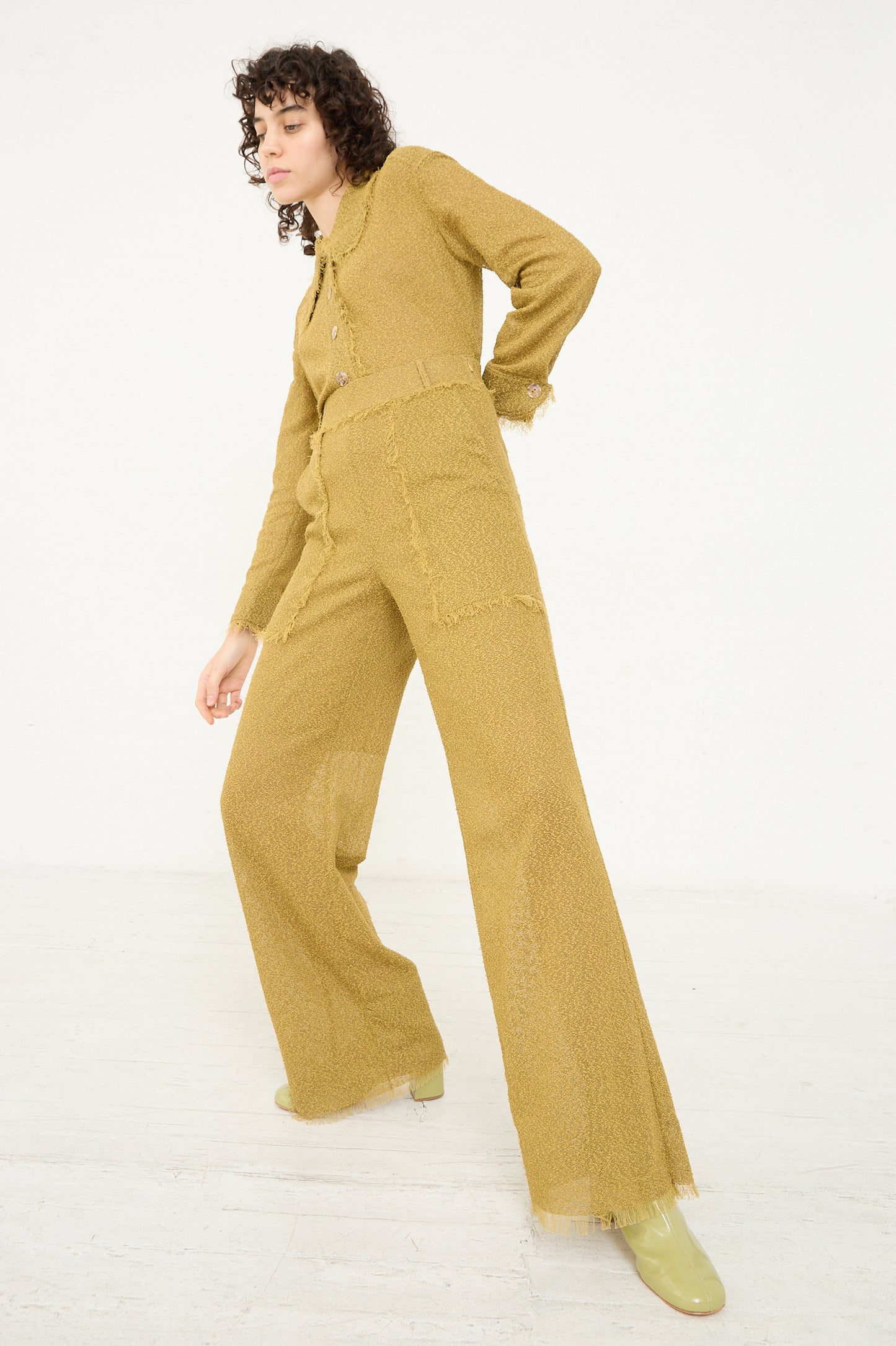 The model is wearing a Tweed Frayed Trouser in Cumin with oversized patch pockets from Veronique Leroy.
