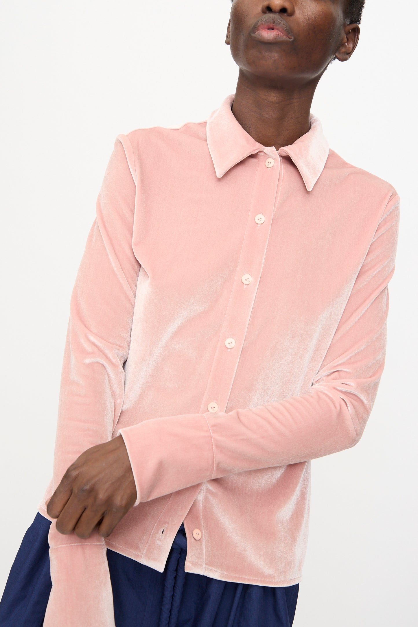 Someone wears the Veronique Leroy Velvet Classic Shirt in Blush with dark blue pants, standing against a plain light background.