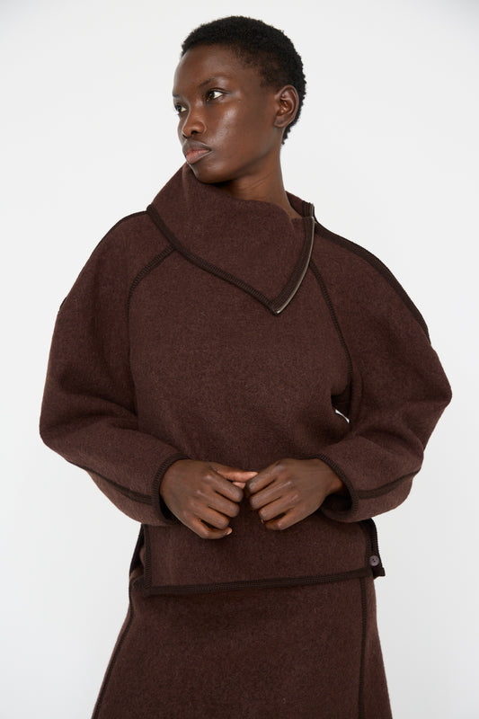 A person wearing the Wool Zip Neck Sweater in Choco by Veronique Leroy, made from luxurious Italian boiled wool, poses against a plain white background.