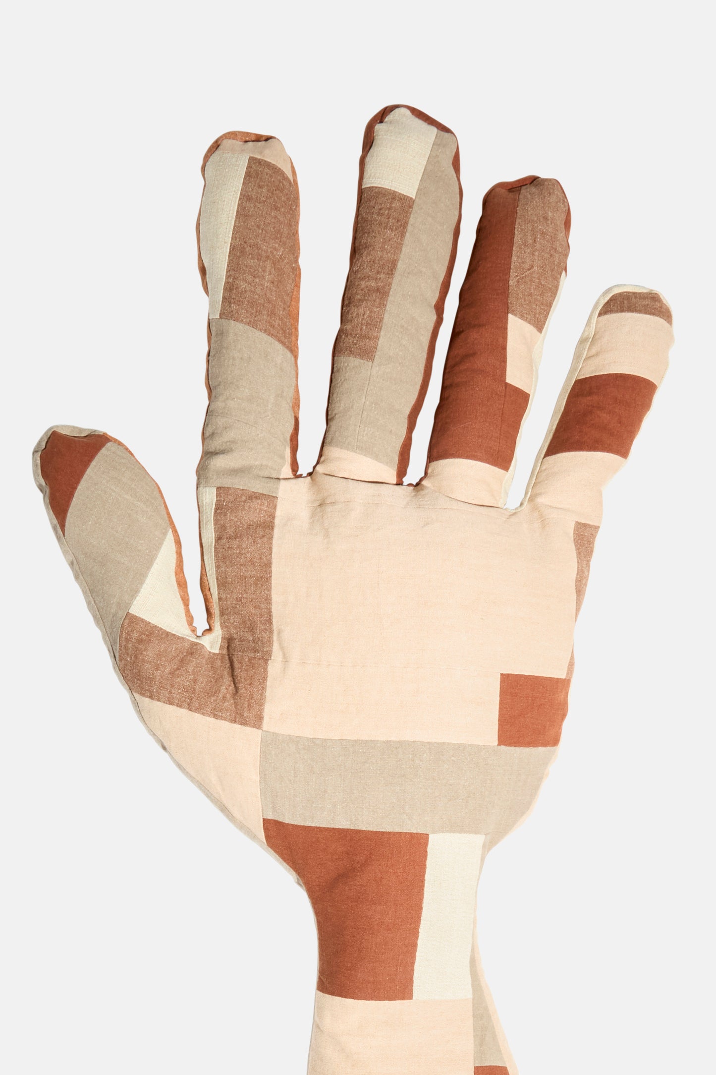 The Sonia Delaunay Tissu Simultané Giant Hand Bolster II by Wiener Times is a hand-shaped pillow from Austria, showcasing a patchwork in brown, beige, and cream that captures the spirit of Wiener Werkstätte design.