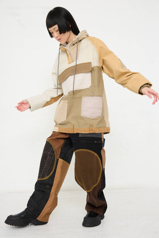 A person with short, dark hair is wearing the Anorak in Beige and Brown by WildRootz. They are standing against a plain white background and looking down.