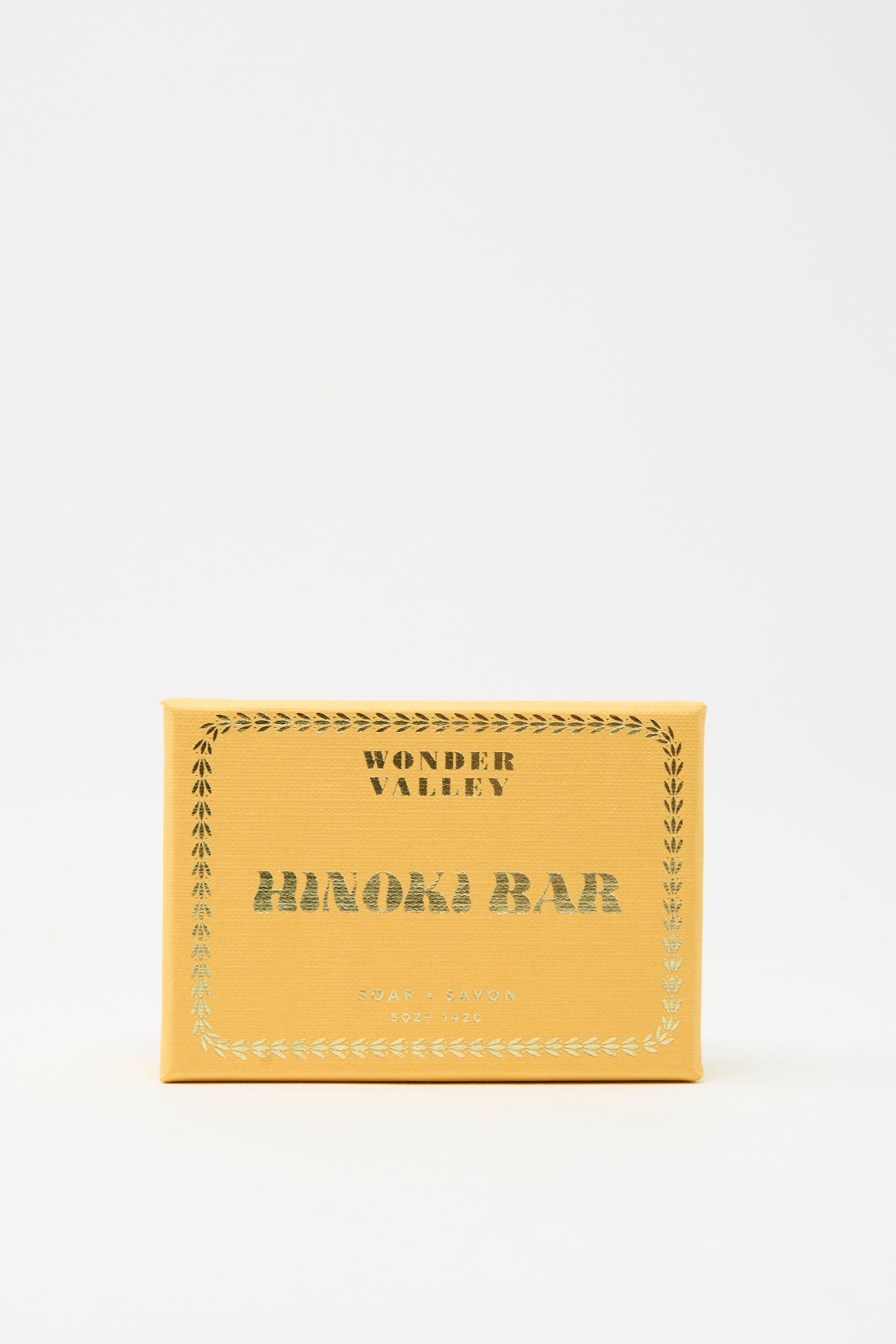 A yellow rectangular Wonder Valley box with silver edging displays their vegan, cruelty-free Hinoki Bar Soap, shown against a plain white background.