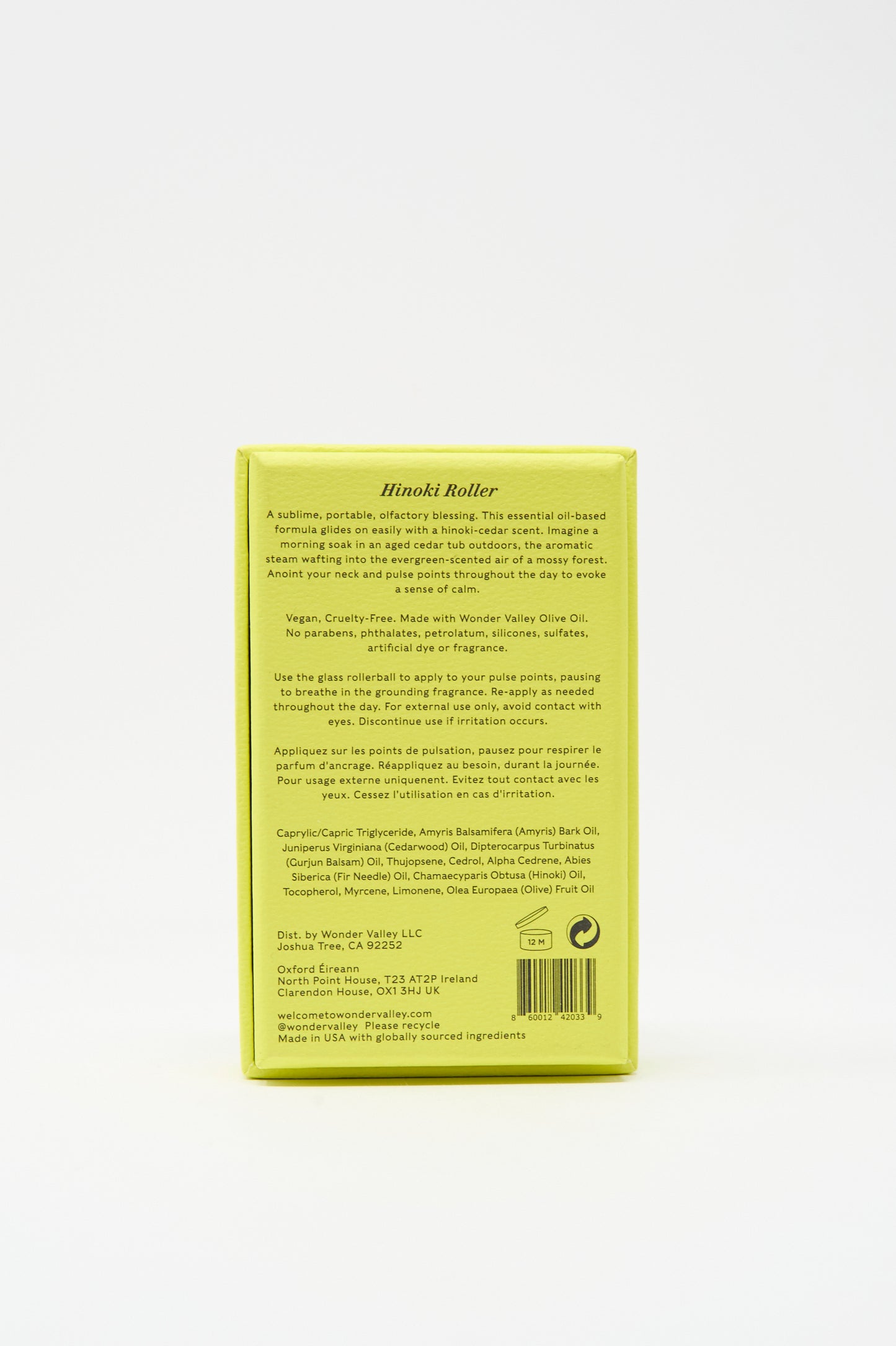 The upright yellow rectangular box displays product info, usage directions, ingredients, and company details—ideal packaging for your Wonder Valley Hinoki Roller, a portable hinoki cedar scent or essential oil-based perfume.