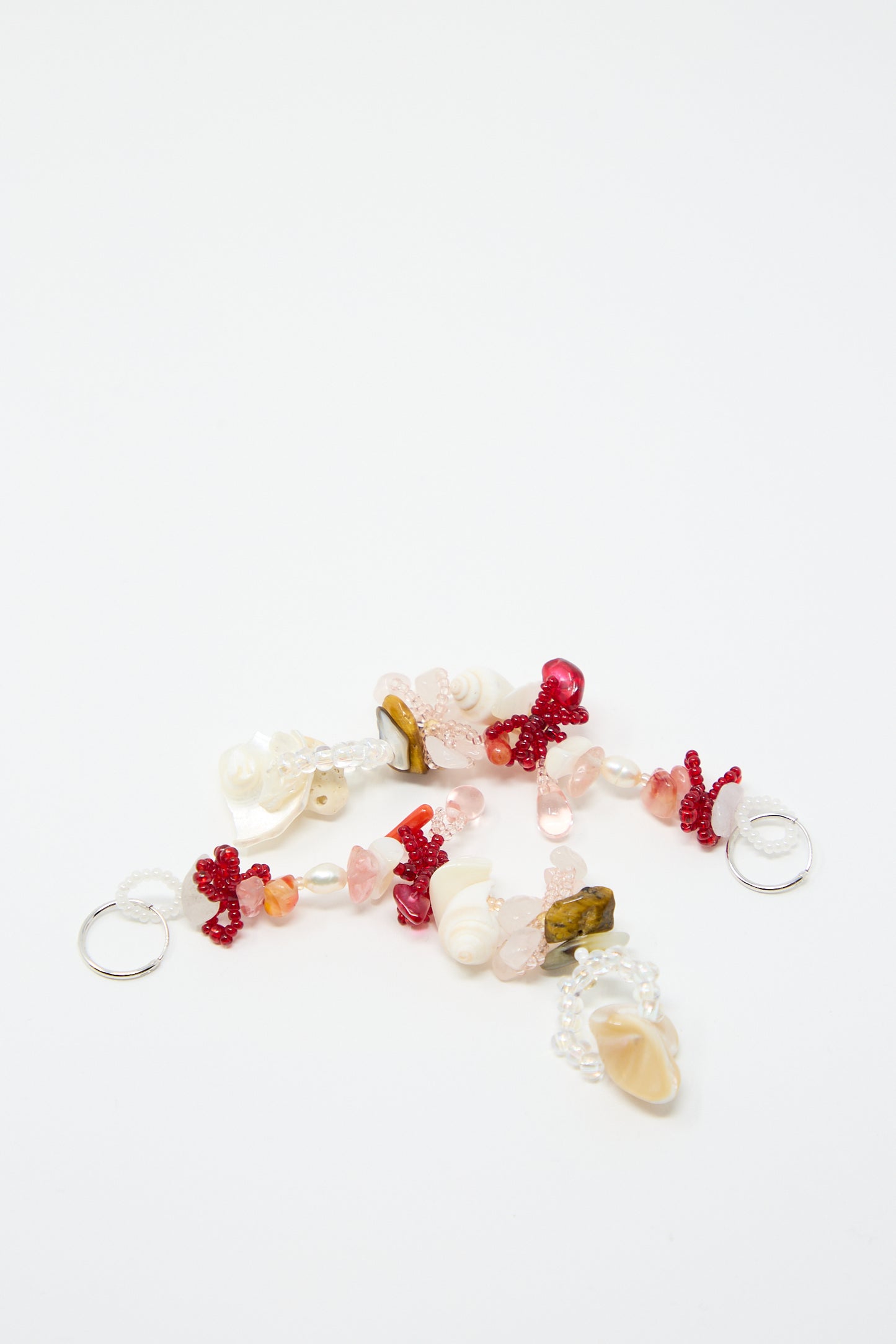 Two beaded keychains featuring a vibrant mix of pink, white, red, and orange beads, adorned with seashells and coral pieces, laid out on a pristine white background. Each piece is crafted to beautifully complement the Kiraz Earrings from Yona Kohen's hand-beaded earrings collection.