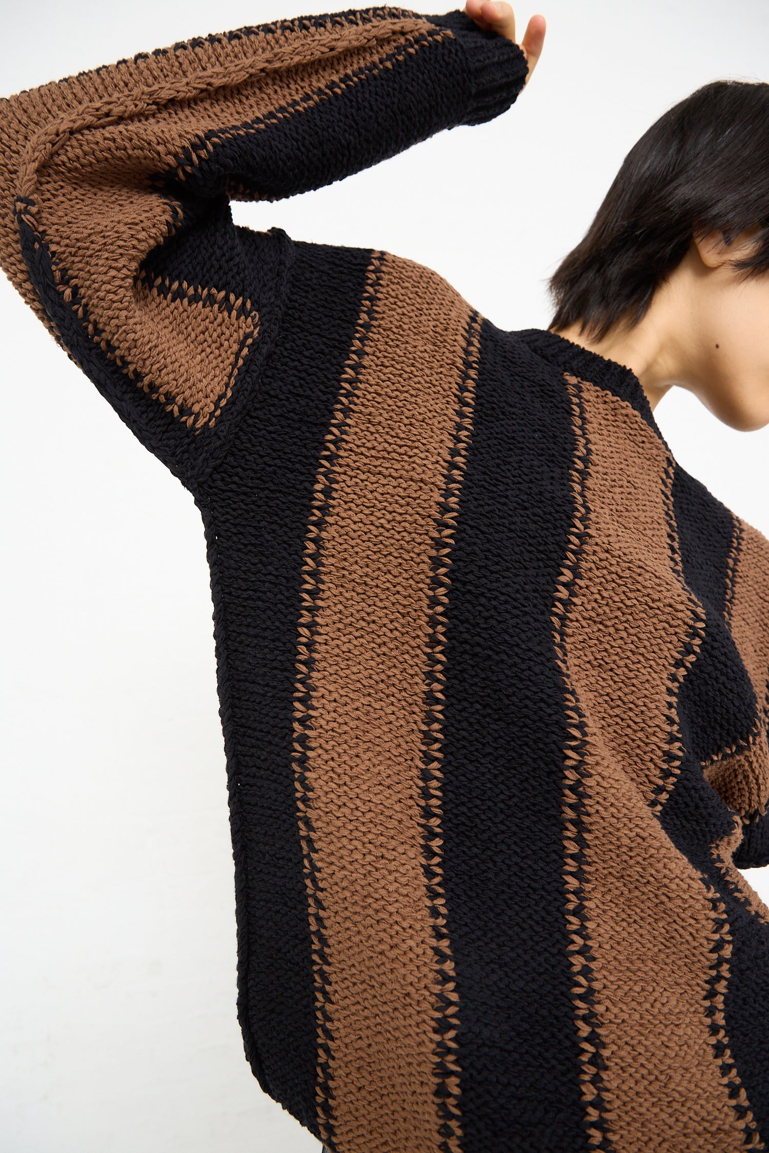A model wearing a Fettuccia Striped Sweater in Black and Noisette by Cristaseya - OROBORO NYC