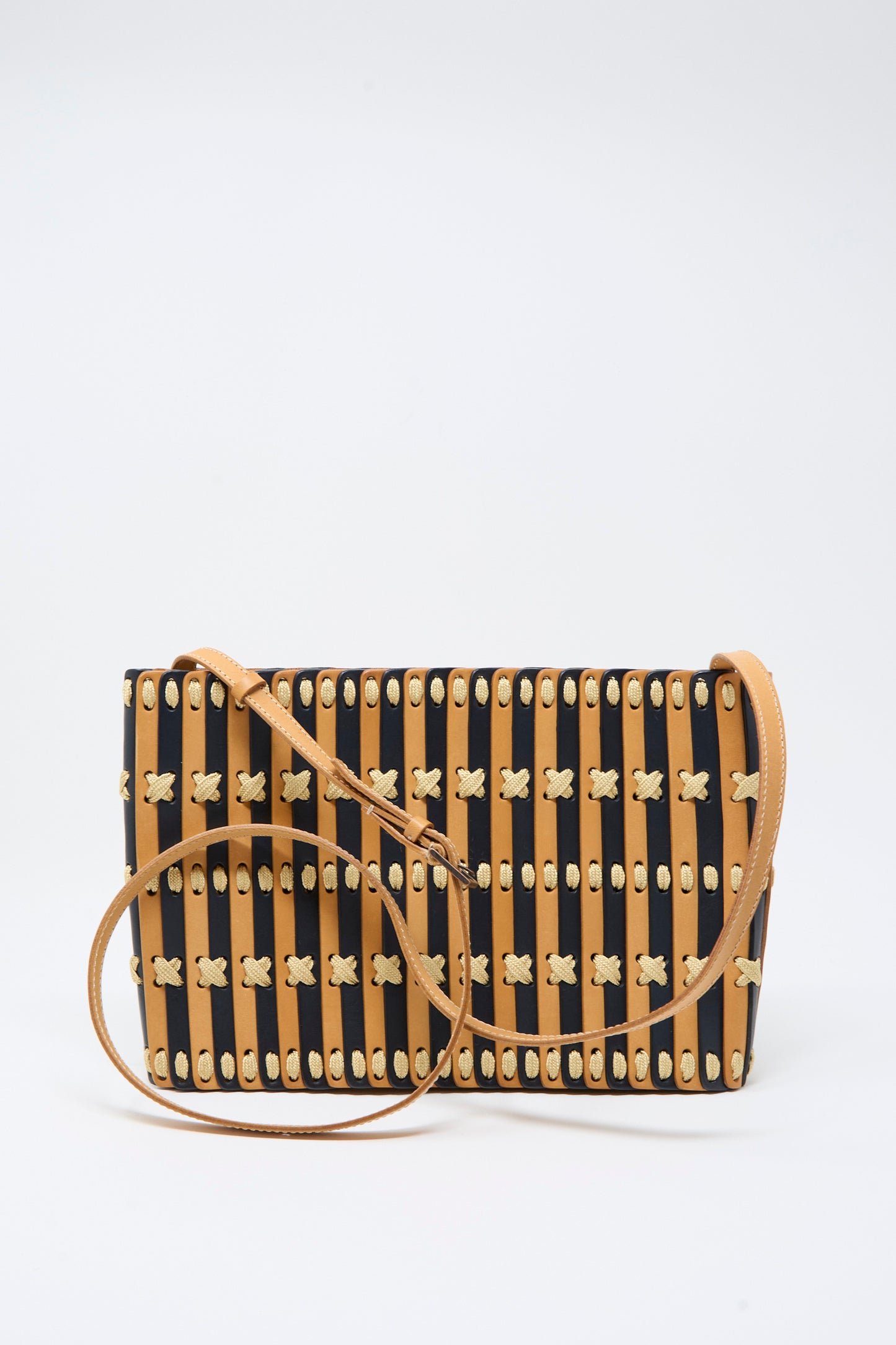 The Hatori Leather Shoulder 60 Bag in Bi-Color with Tan Lacing features a rectangular, handcrafted design with vertical brown and black stripes, yellow woven accents, and a thin brown vegetable-tanned leather strap, displayed on a plain white background.