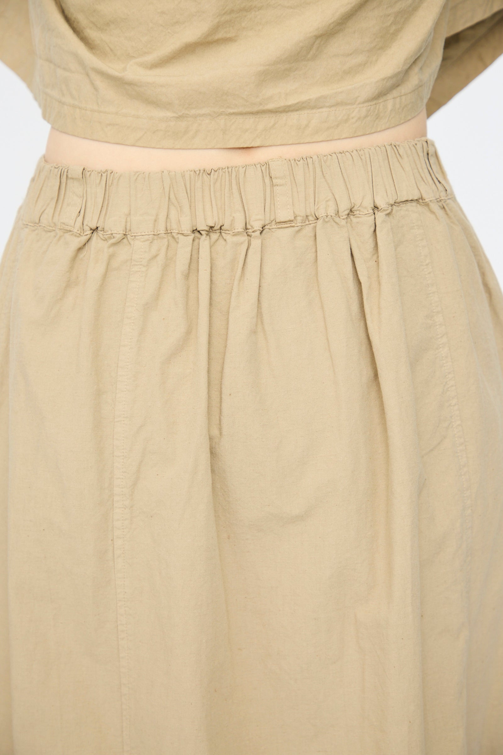 Close-up of the nest Robe Cotton Linen Dungaree Balloon Skirt in Beige, featuring a high-waisted elastic waistband and relaxed fit, styled with a matching cropped top.