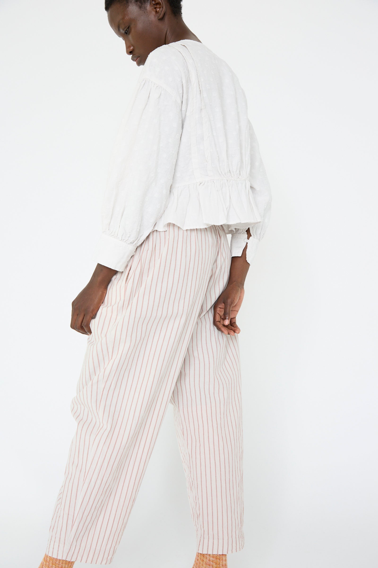 A woman in a white top, wearing the Cotton Linen Easy Pants in Stripe by nest Robe.