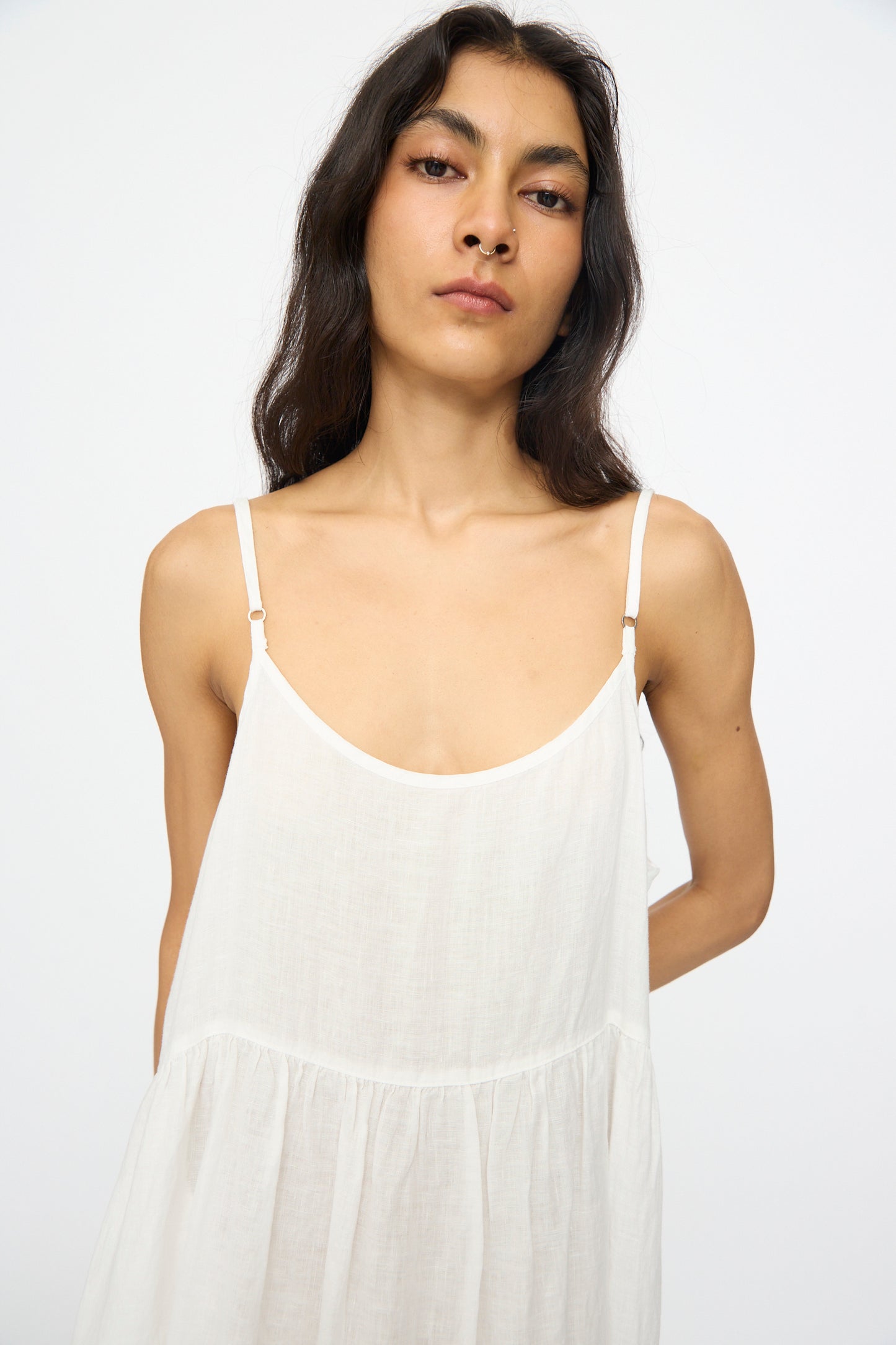 A woman with long dark hair models the nest Robe Linen Cotton Lace-Hem Cami Dress in Off White, standing against a simple light background and looking directly at the camera.