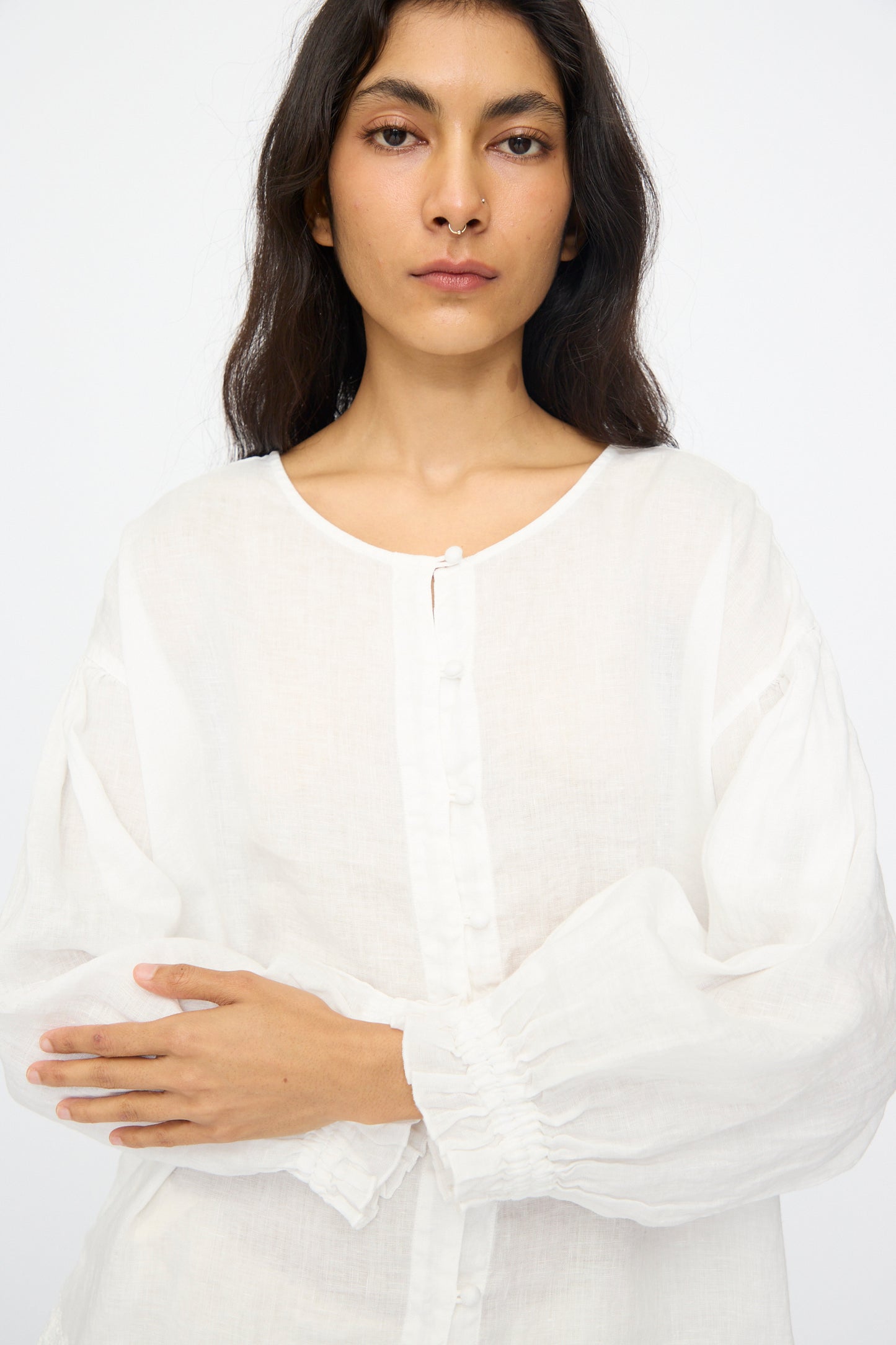 A woman with long dark hair wears the nest Robe Linen Cotton Lace-Hem Two Way Blouse in Off White, standing against a plain white background.