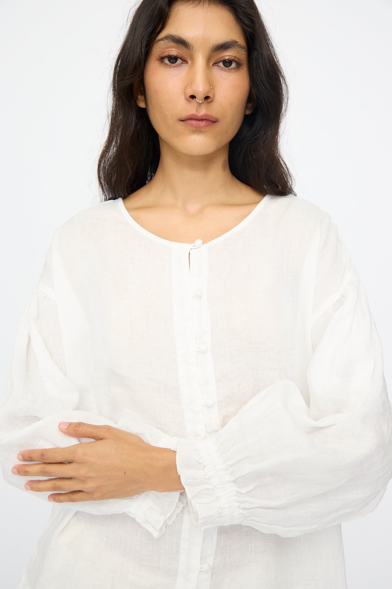 A woman with long dark hair wears the nest Robe Linen Cotton Lace-Hem Two Way Blouse in Off White, standing against a plain white background.