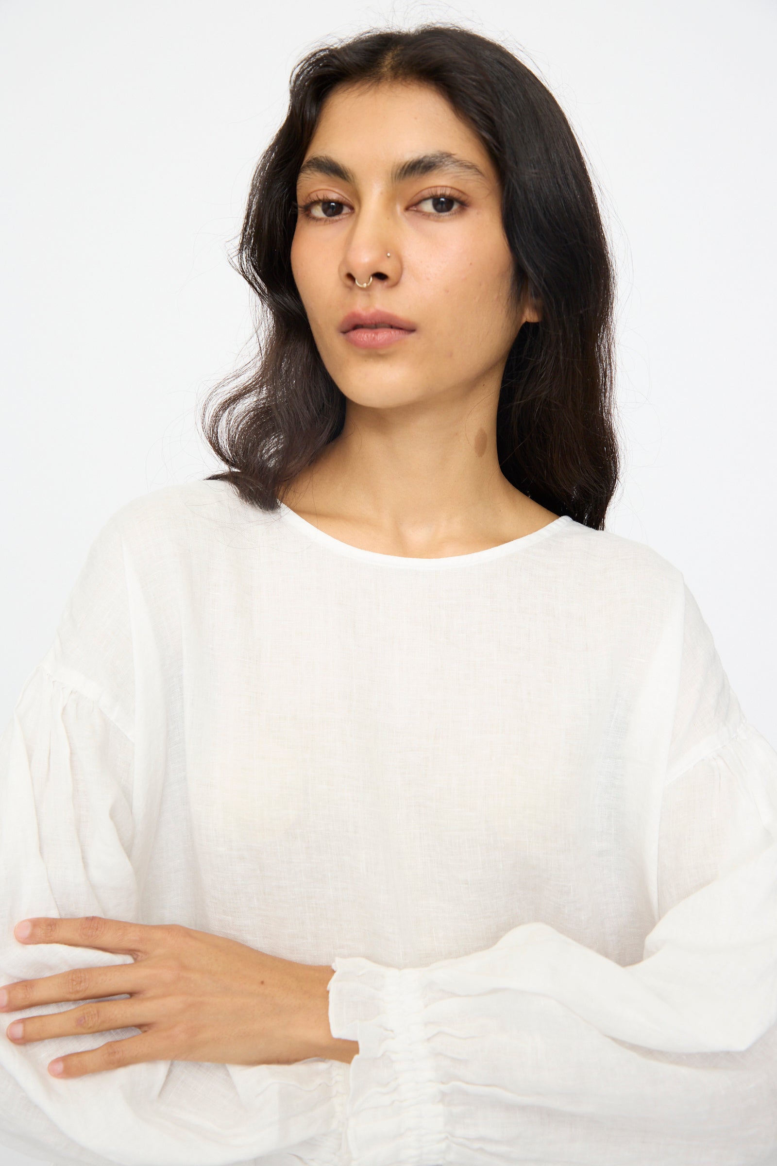 A person with long dark hair, wearing the nest Robe Linen Cotton Lace-Hem Two Way Blouse in Off White, stands against a plain light background, looking directly at the camera.