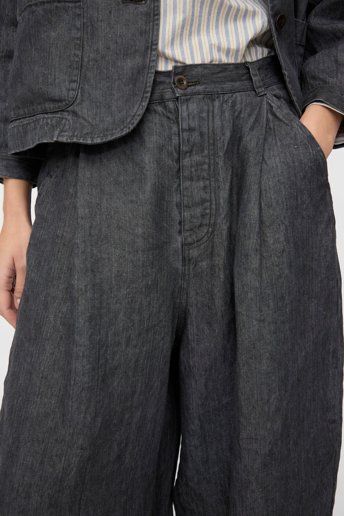 Model wears nest Robe's Linen Denim Wide Pants in Black, styled high-waisted and wide-leg with a matching jacket over a striped shirt; shown from waist to mid-thigh.