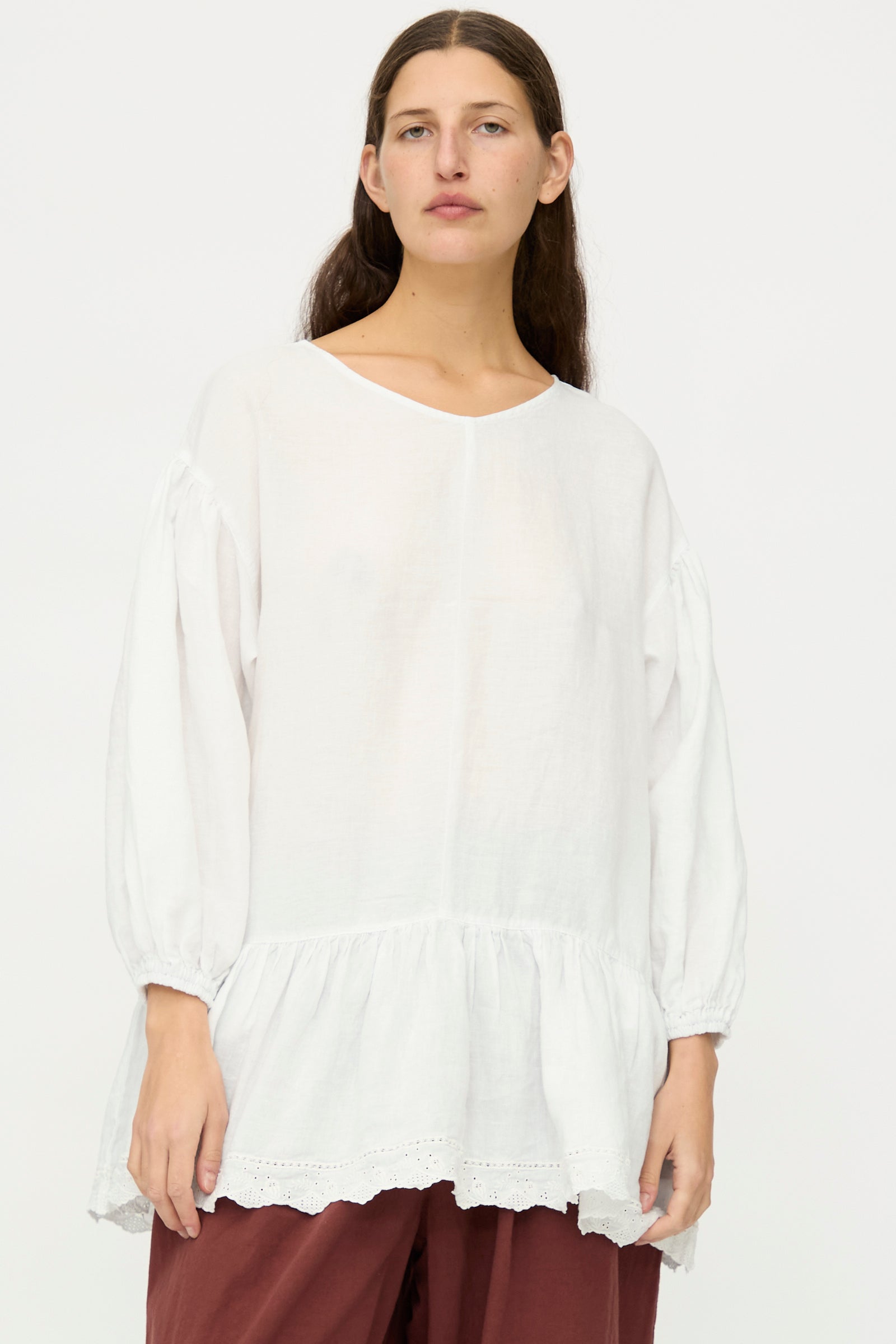 A person with long brown hair wears the nest Robe Linen Scallop Lace Two-Way Tunic, styled loose with lace embroidery, standing against a plain white background.