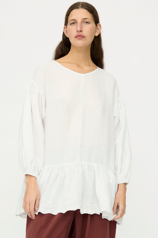 A person with long brown hair wears the nest Robe Linen Scallop Lace Two-Way Tunic, styled loose with lace embroidery, standing against a plain white background.