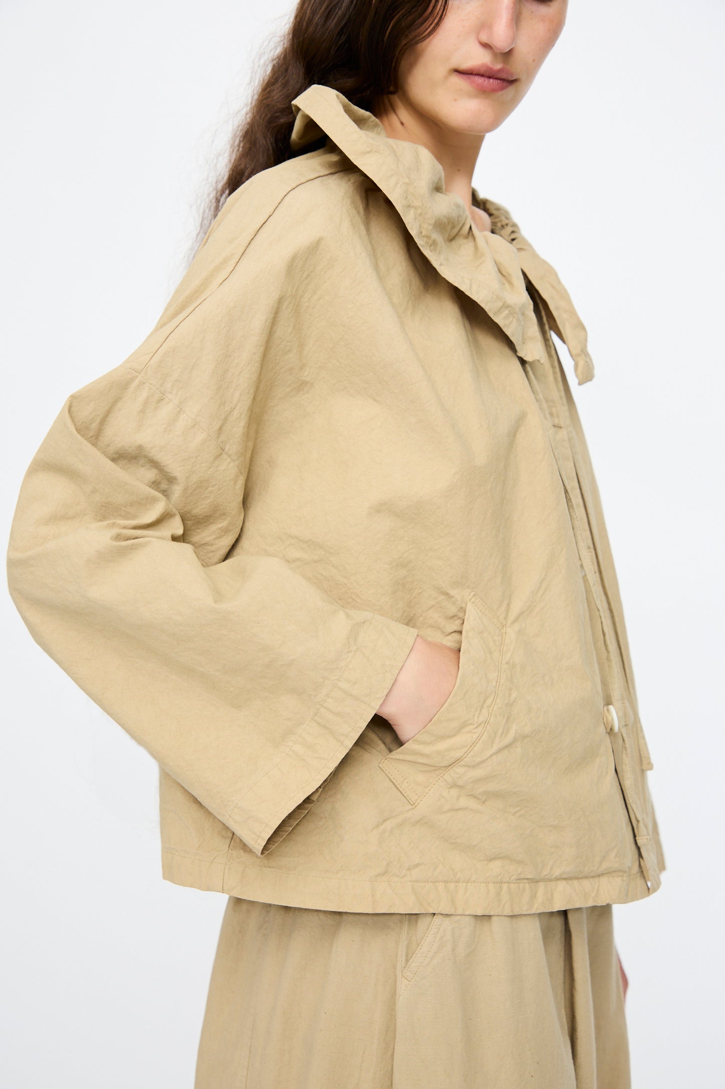 A person wearing the nest Robe Super Water-Repellent Supima Cotton Leaf Collar Jacket in Beige, styled with matching pants and standing against a plain white background.