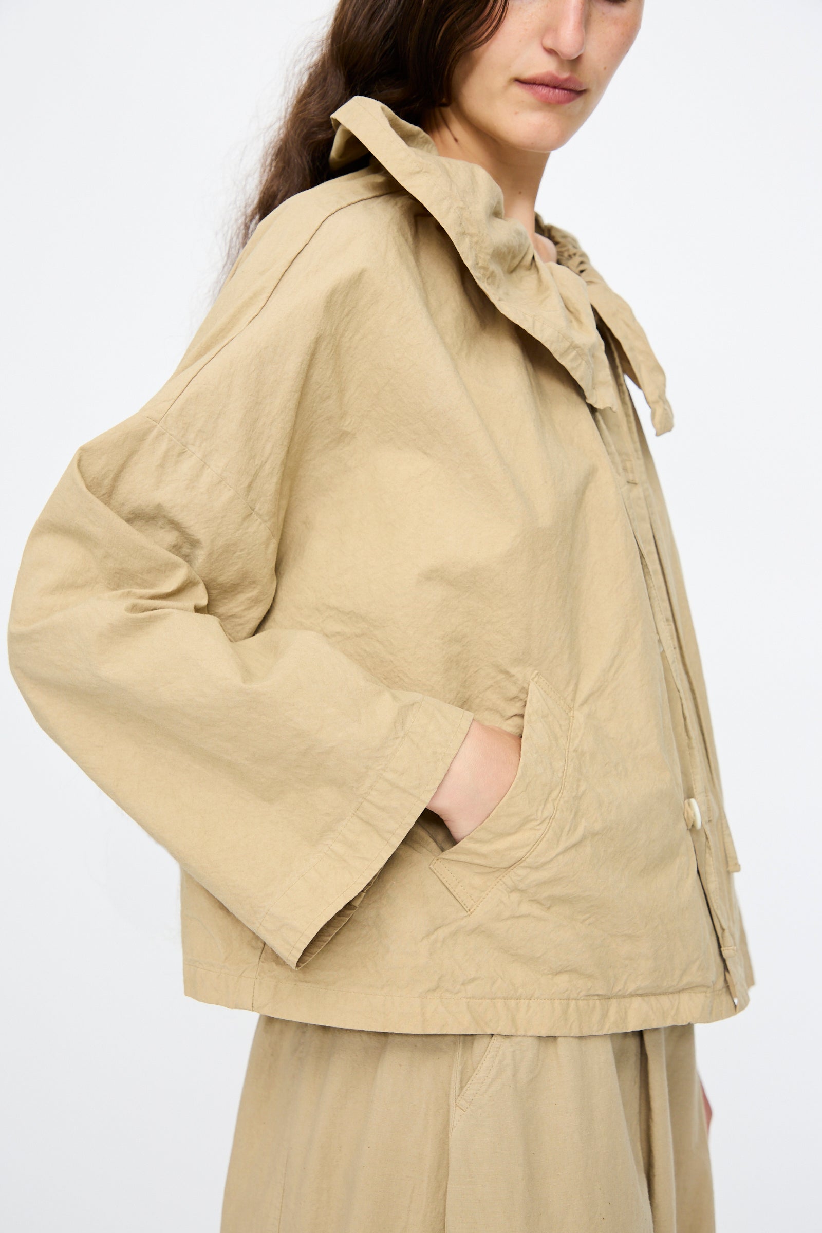 A person wearing the nest Robe Super Water-Repellent Supima Cotton Leaf Collar Jacket in Beige, styled with matching pants and standing against a plain white background.