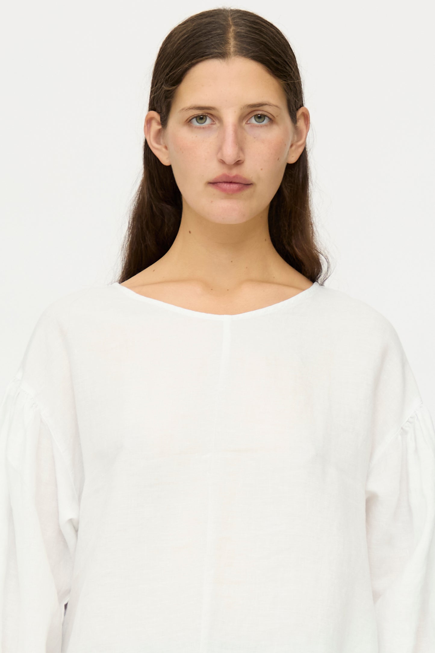 A person with long brown hair and blue eyes wears the nest Robe Linen Scallop Lace Two-Way Tunic, featuring bishop sleeves, standing against a plain white background and looking directly at the camera.