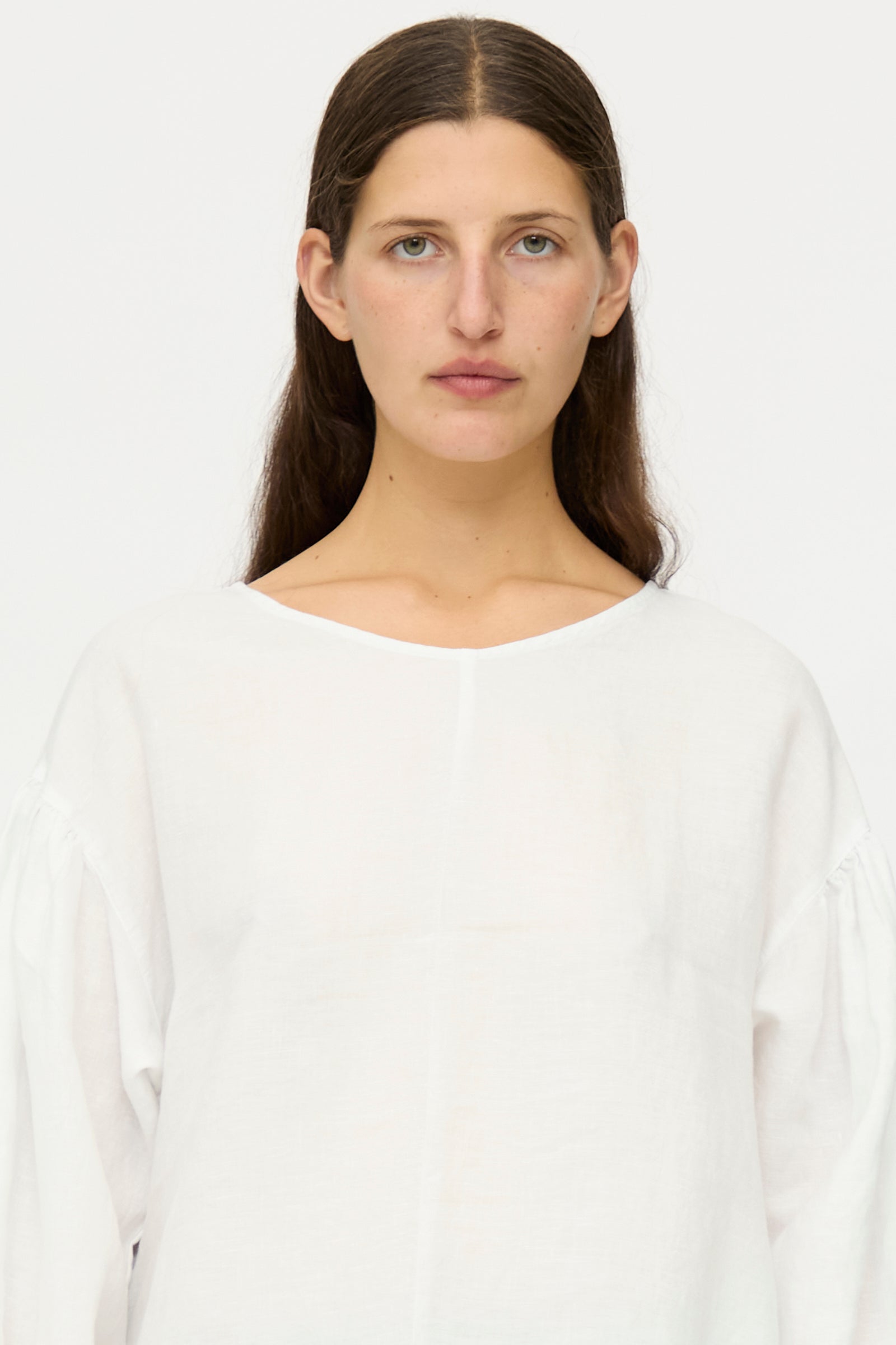 A person with long brown hair and blue eyes wears the nest Robe Linen Scallop Lace Two-Way Tunic, featuring bishop sleeves, standing against a plain white background and looking directly at the camera.