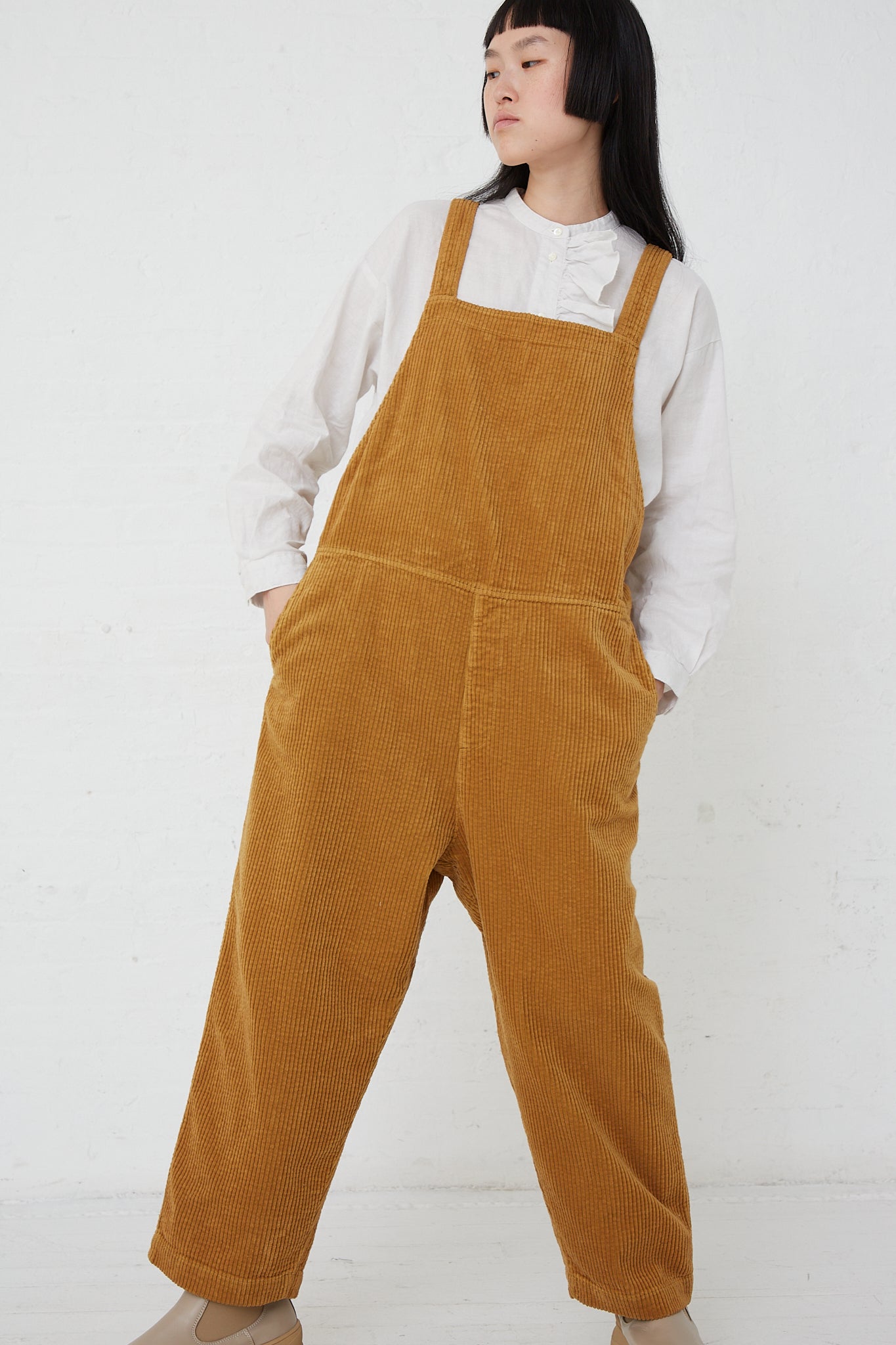 The model is wearing Nest Robe's Cotton Corduroy Overall in Camel.