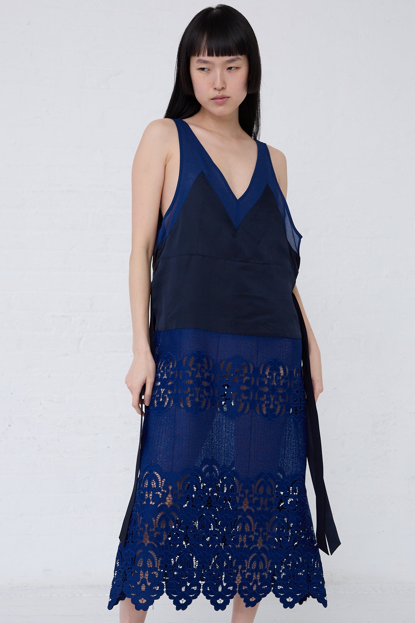 The model is wearing a TOGA PULLA Mesh Lace Dress in Blue.
