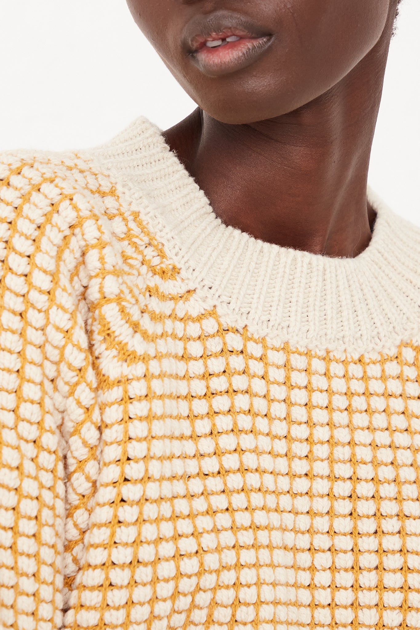 An oversized Crewneck Sweater in a yellow and white two-tone knit design, by Jan-Jan Van Essche.