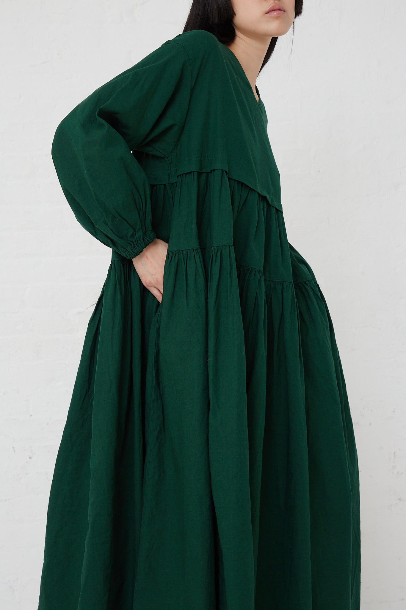 The model is wearing the UpcycleLino Linen Tiered Gather Dress in Green by nest Robe, made with ruffles.