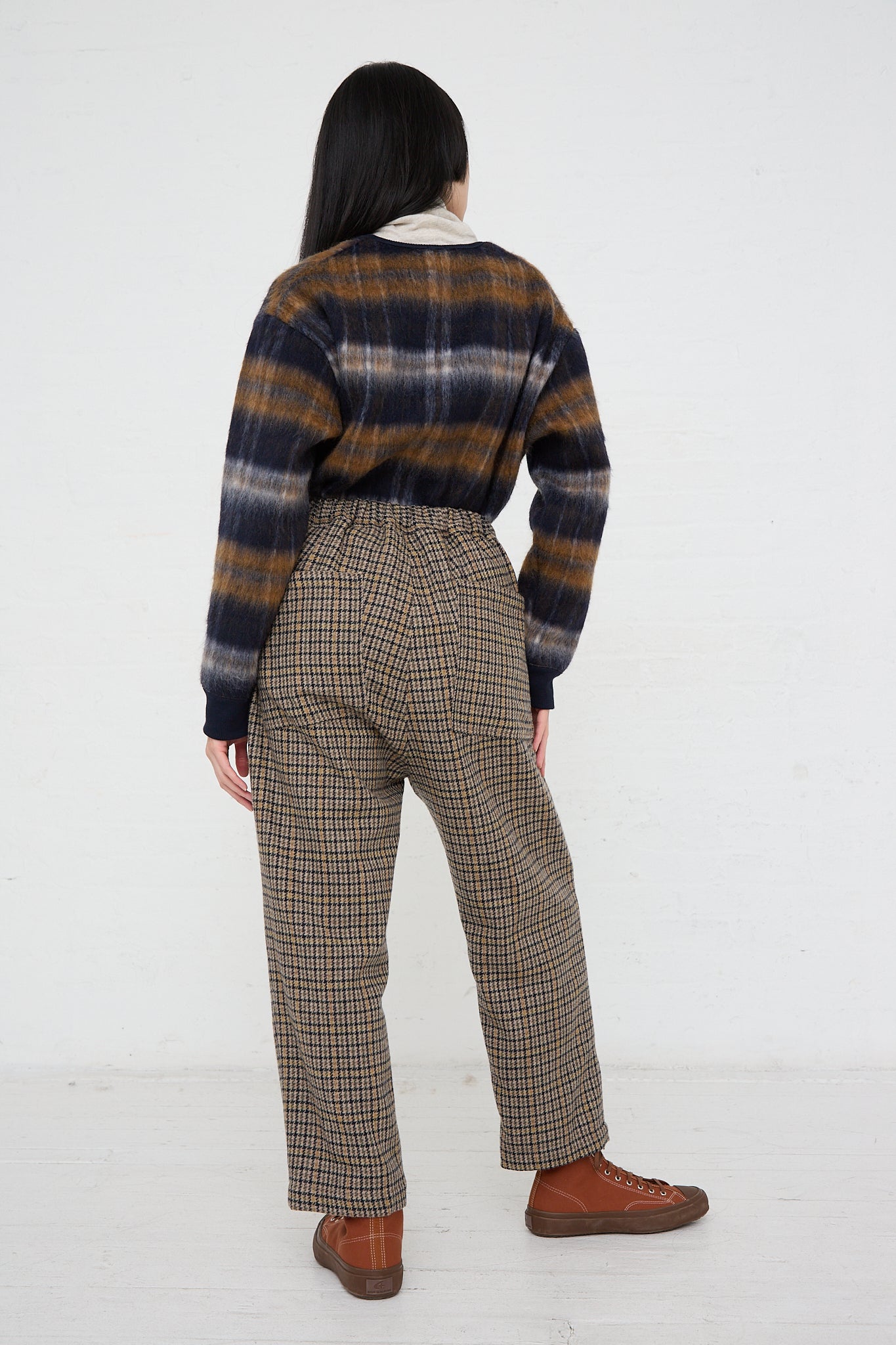 The back of a woman wearing Ichi's woven Pant in Mocha Check and check wool blend sweater. Full length.