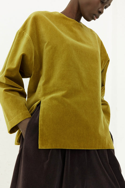 A model wearing a yellow Cotton Velveteen Slit Top in Olive by Black Crane. Front view.