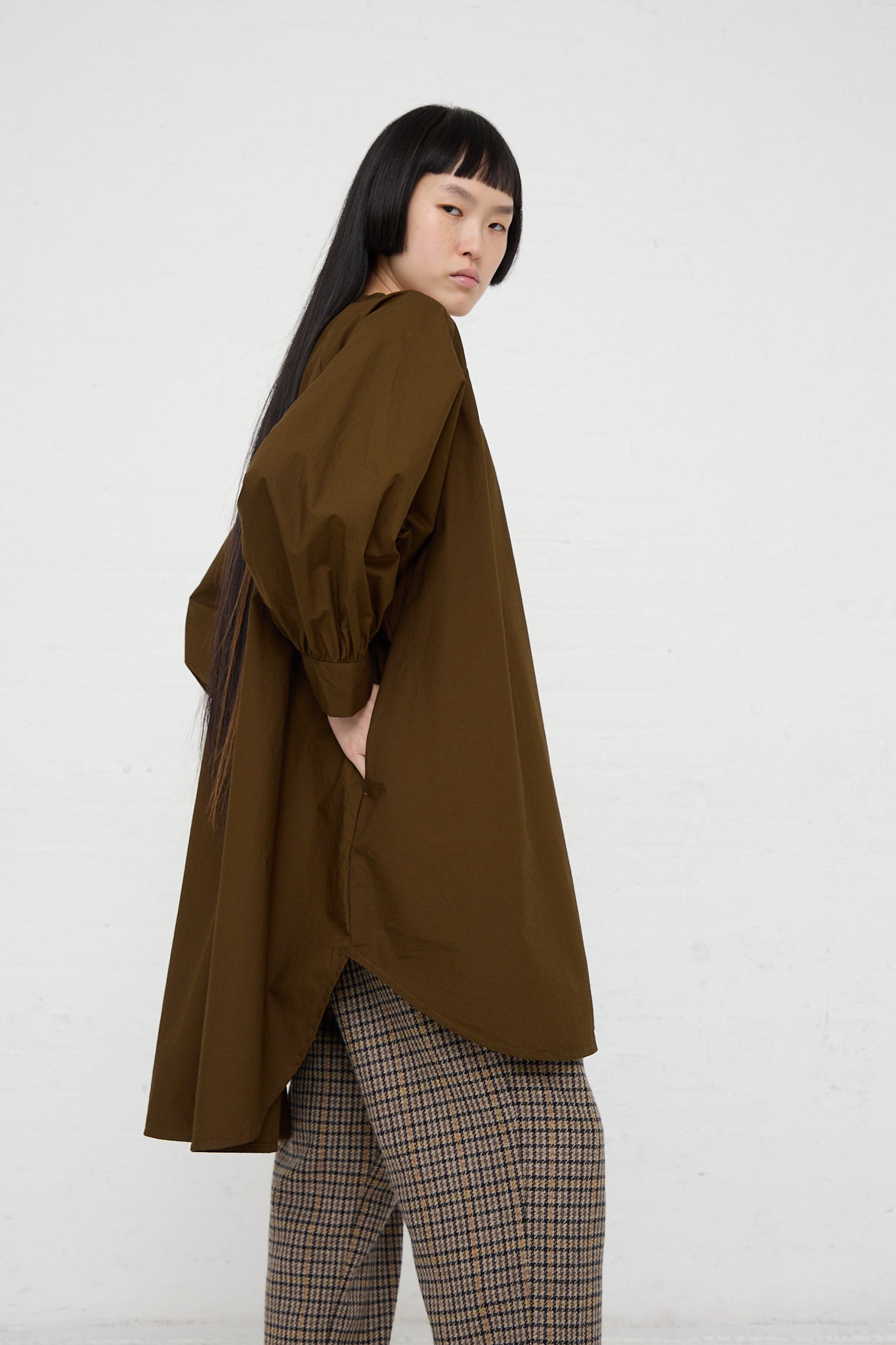 The model is wearing a Ichi woven cotton shirt in seal brown with a wide band collar. Side view.