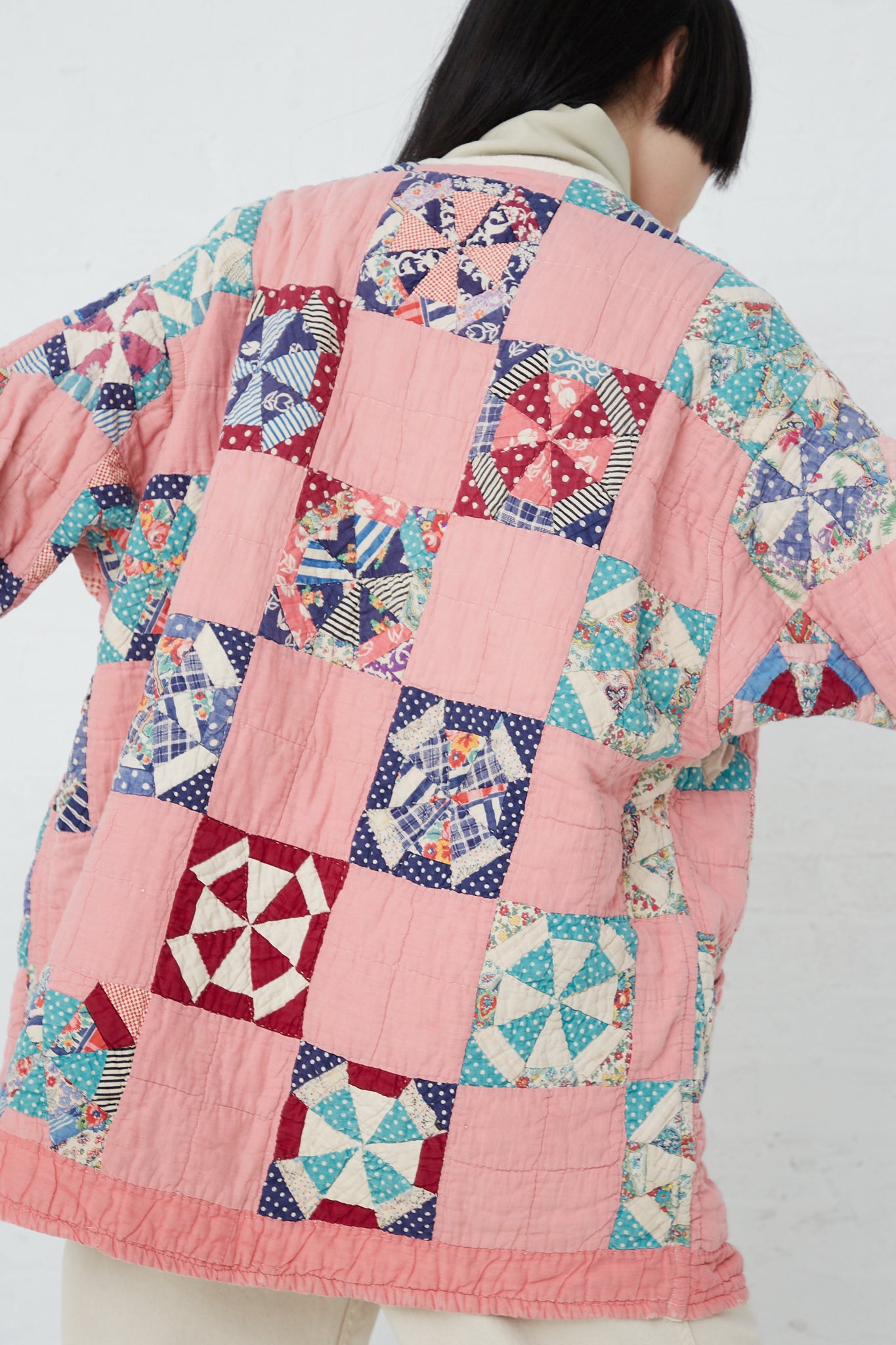 The back of a woman wearing an As Ever Quilt Jacket in Pink.