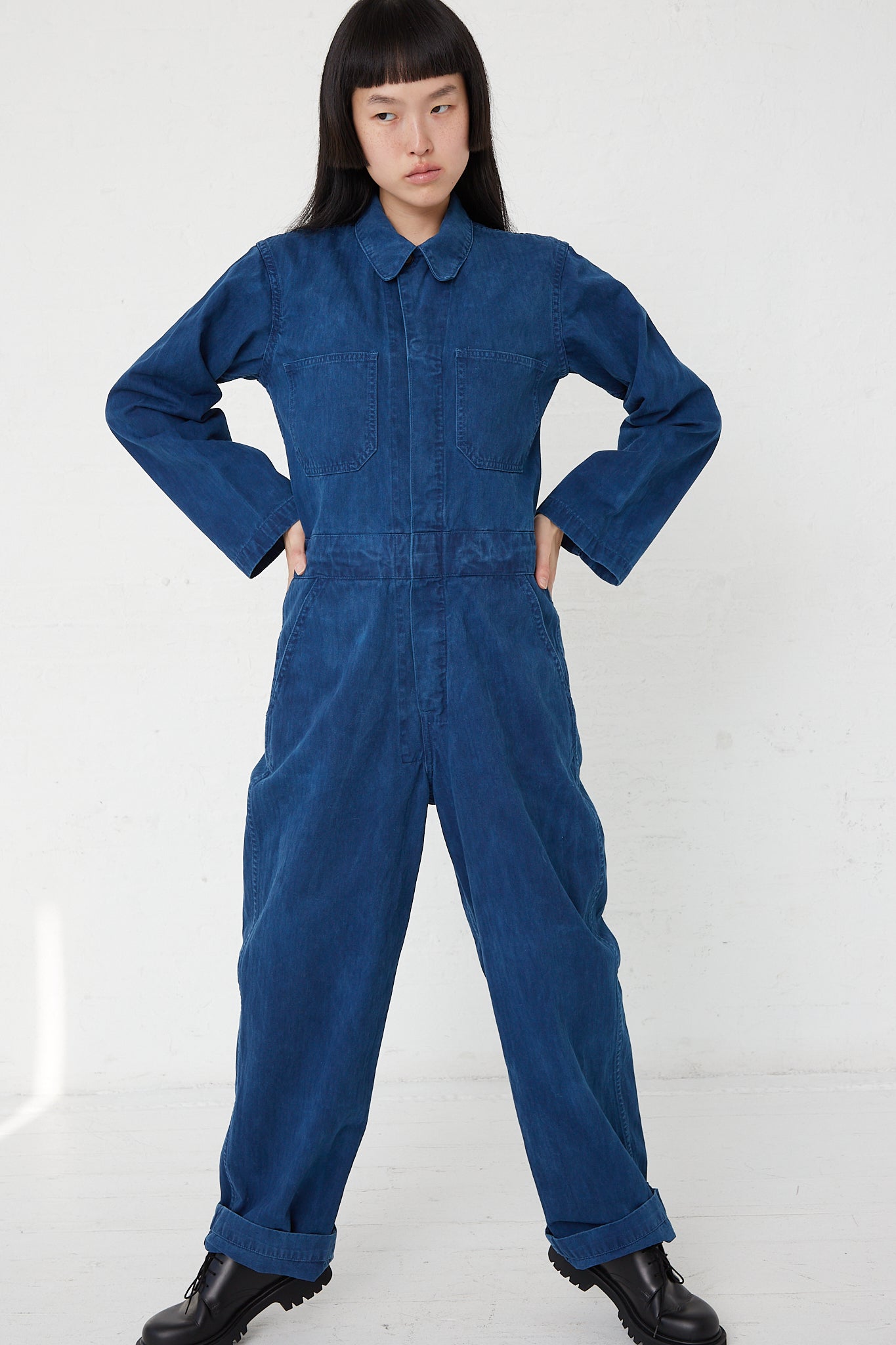 A woman in an As Ever front zip jumpsuit in Indigo posing for a photo.