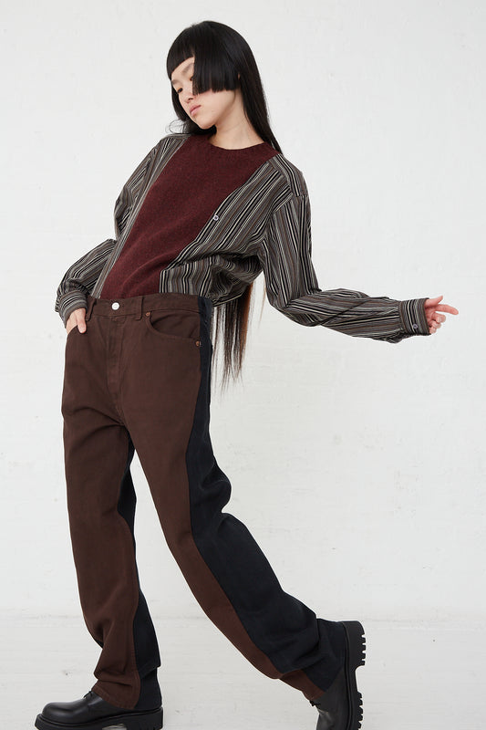 A woman in Bless Jeanspleatfront No. 73 in Surprise Color Mix C denim pants wearing a striped shirt.