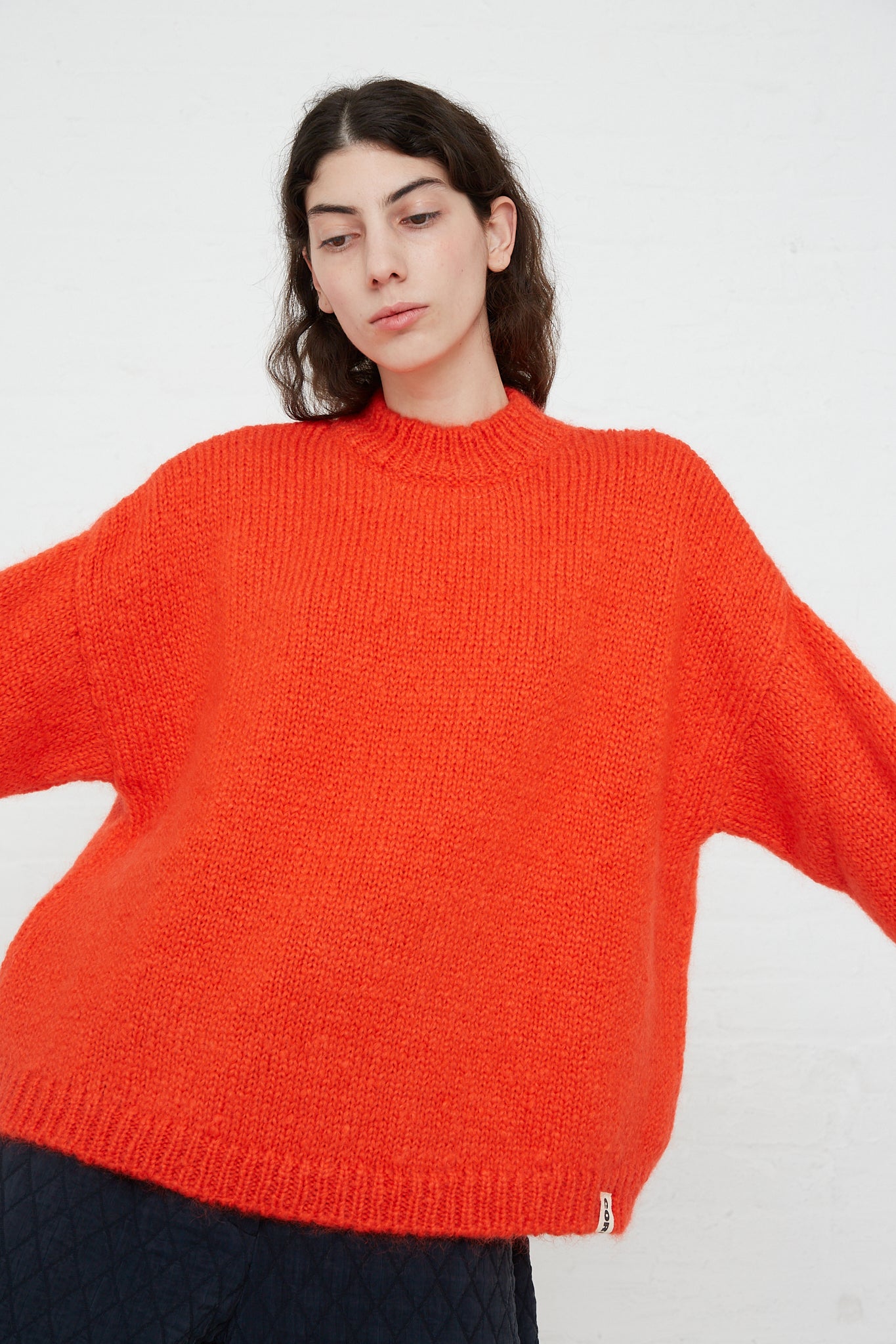 A model wearing a Cordera Mohair Sweater in Tangerine blend. Front view.