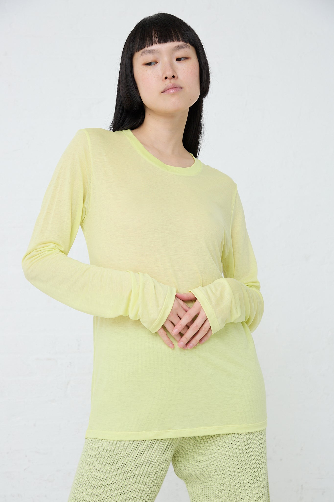 The model is wearing a Baserange Bamboo Long Sleeve Tee in Lime made of sustainable bamboo lyocell. Front view.