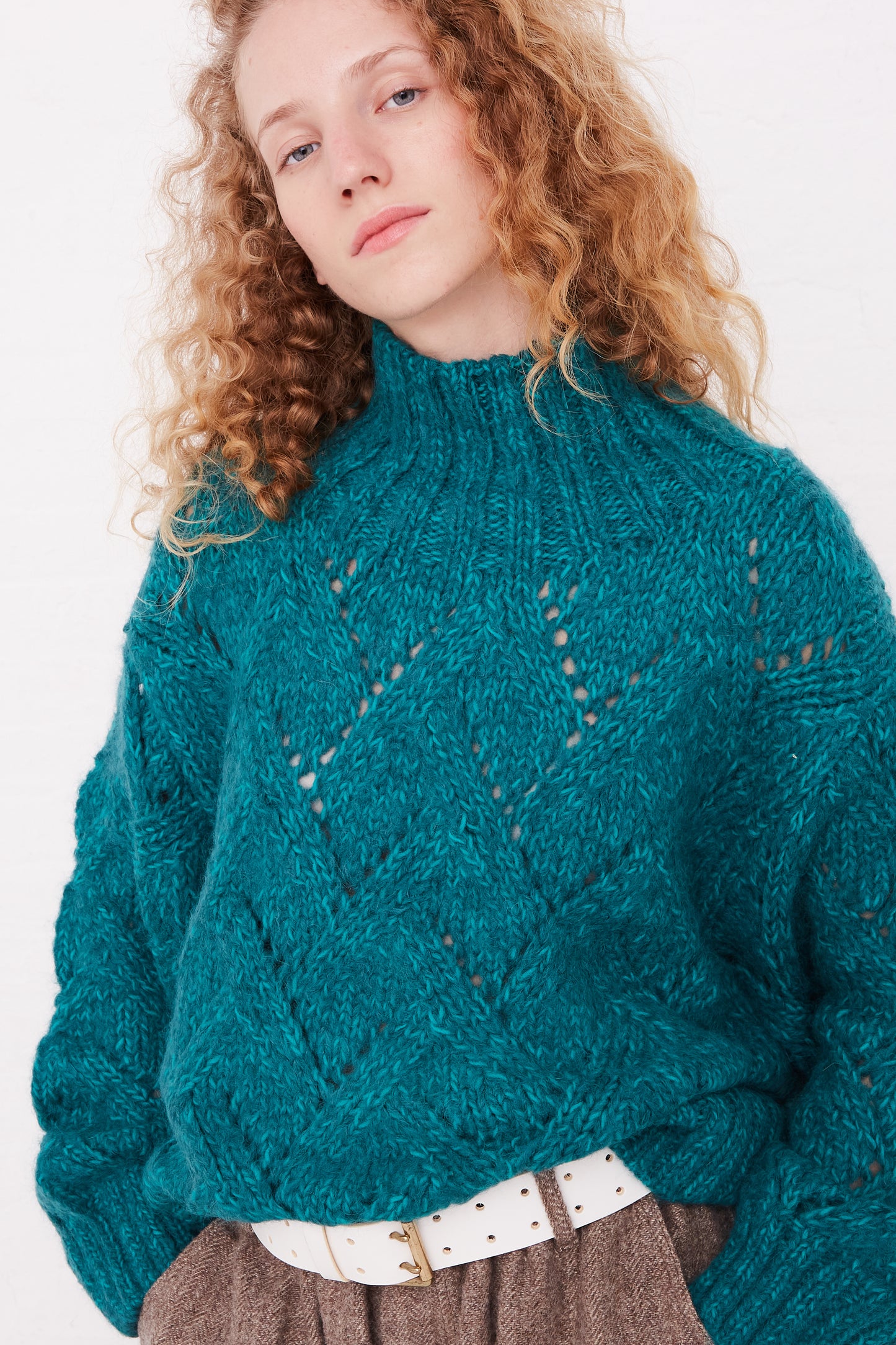 A woman wearing an oversized Ichi Antiquités Hand-Knit Turtleneck in Green Teal sweater.