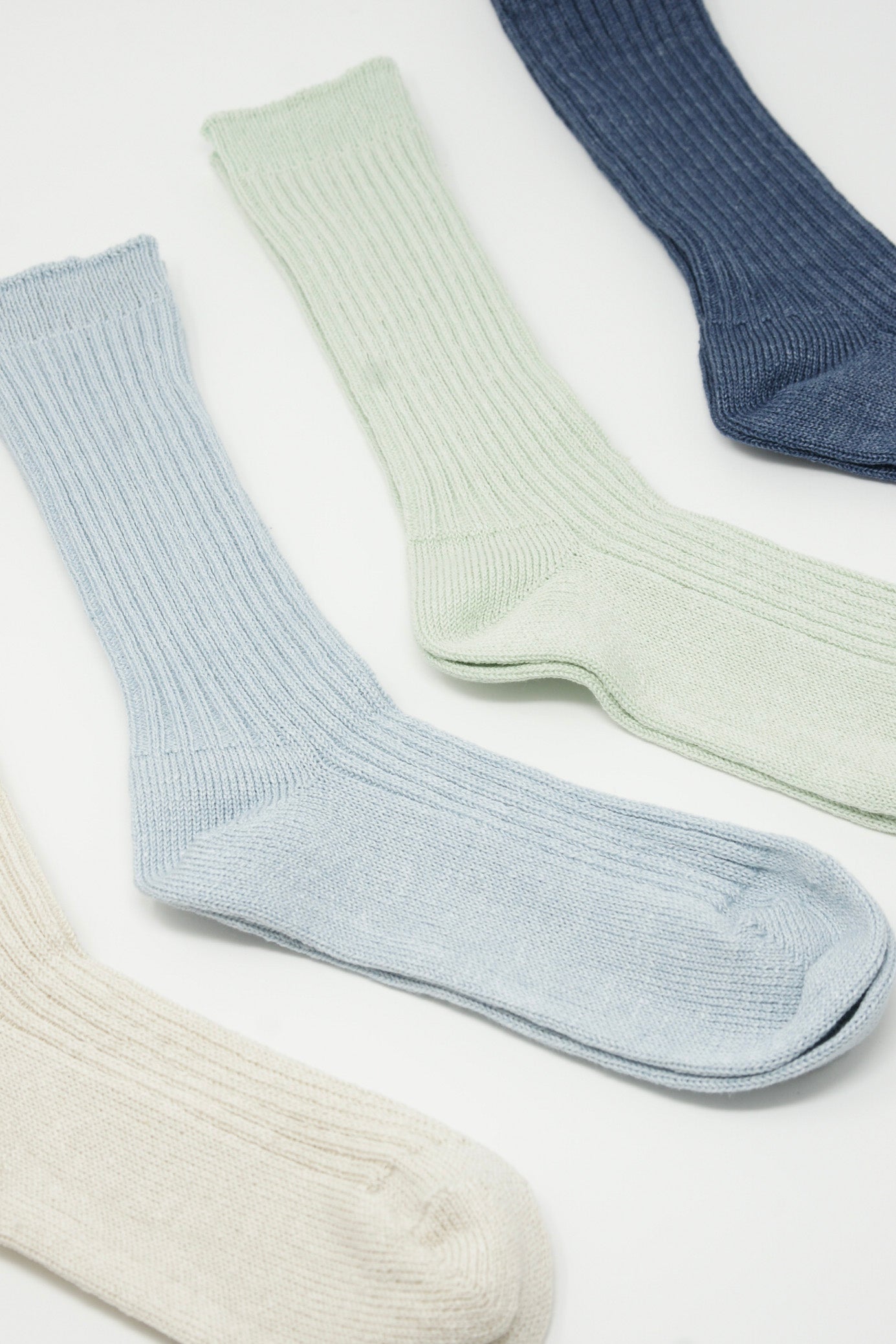 Four pairs of Linen Rib Socks in Light Blue by Ichi Antiquités on a white surface in Fukuoka Japan.
