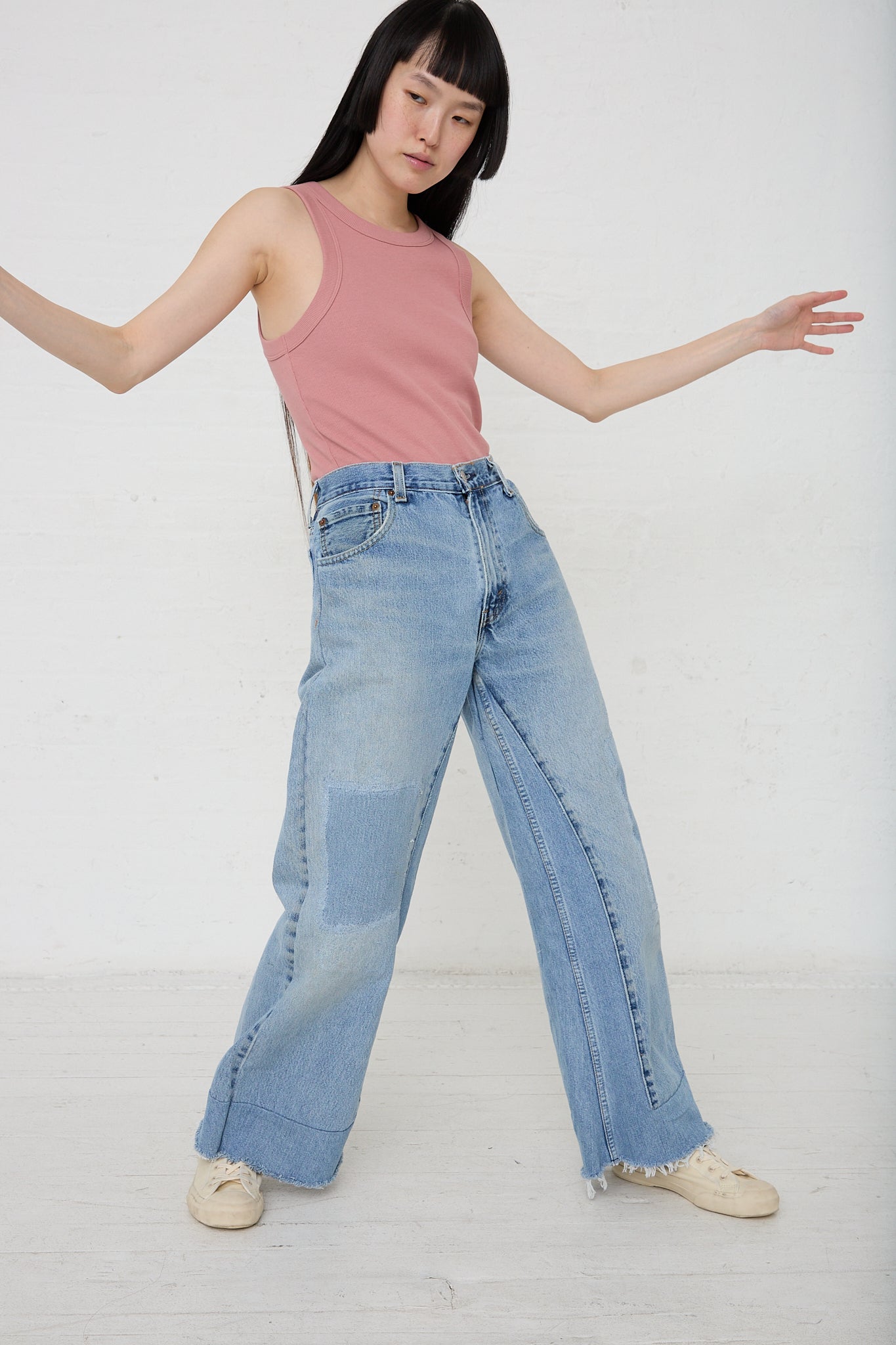 A woman in B Sides' Reworked Culotte in Vintage Indigo shorts and a pink tank top.