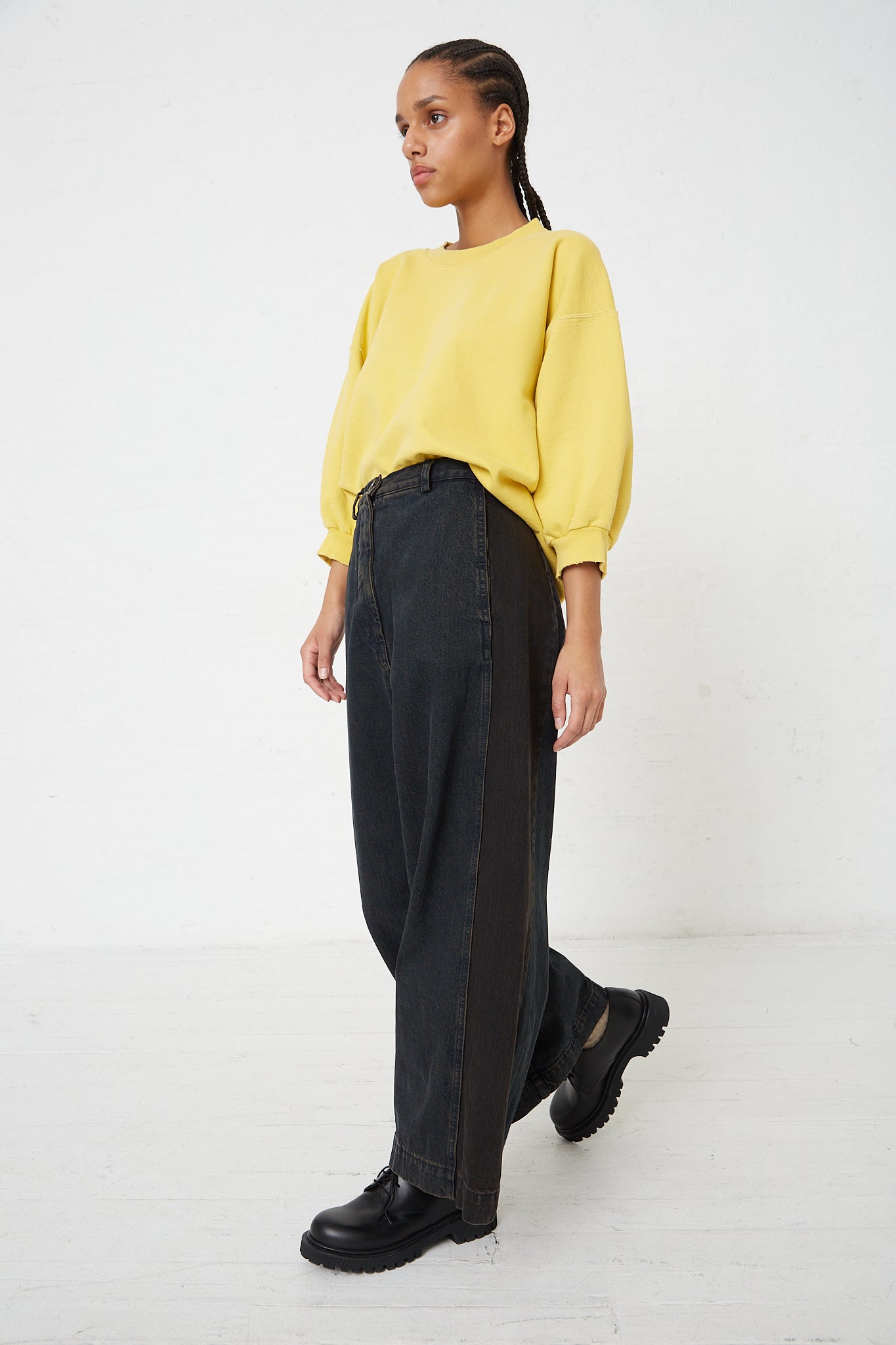 The model is wearing a yellow sweater and Denim Garra Pant in Brown by Rachel Comey in a relaxed fit.