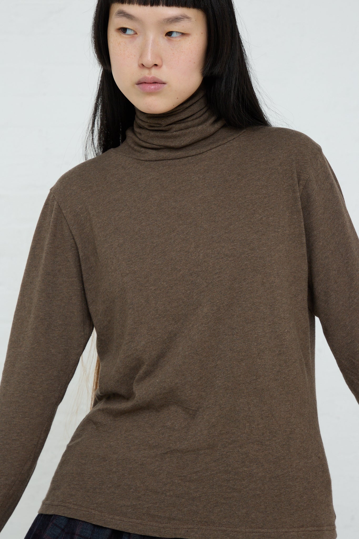 The model is wearing a relaxed fit, long sleeve brown turtleneck, made of Ichi's Cotton Knit Turtleneck in Mocha.