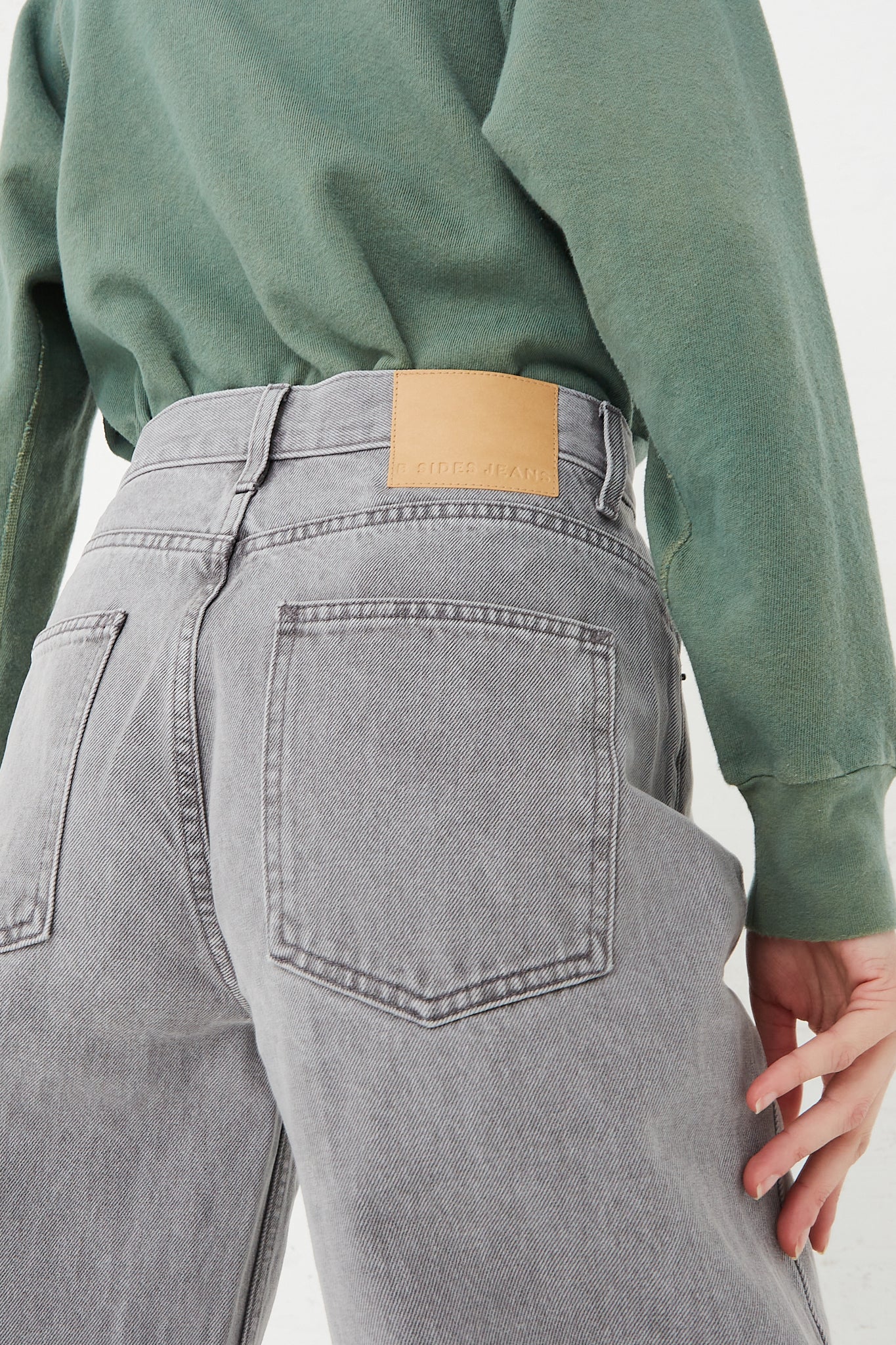 The back view of a model wearing B Sides Leroy Mid Relaxed Bow Jean in Grey Stone jeans.