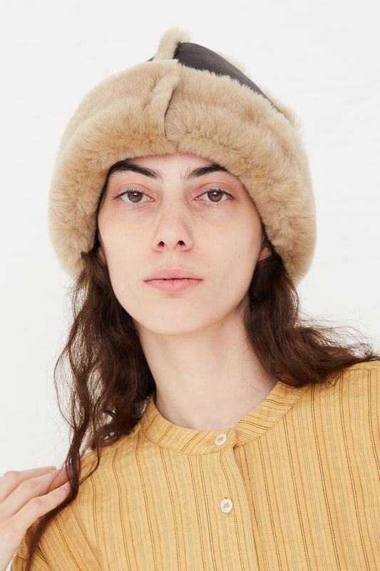 A model wearing a fitted hat in a sheepskin leather.  Head straight on featuring sheepskin. Designed by Cawley - Oroboro Store