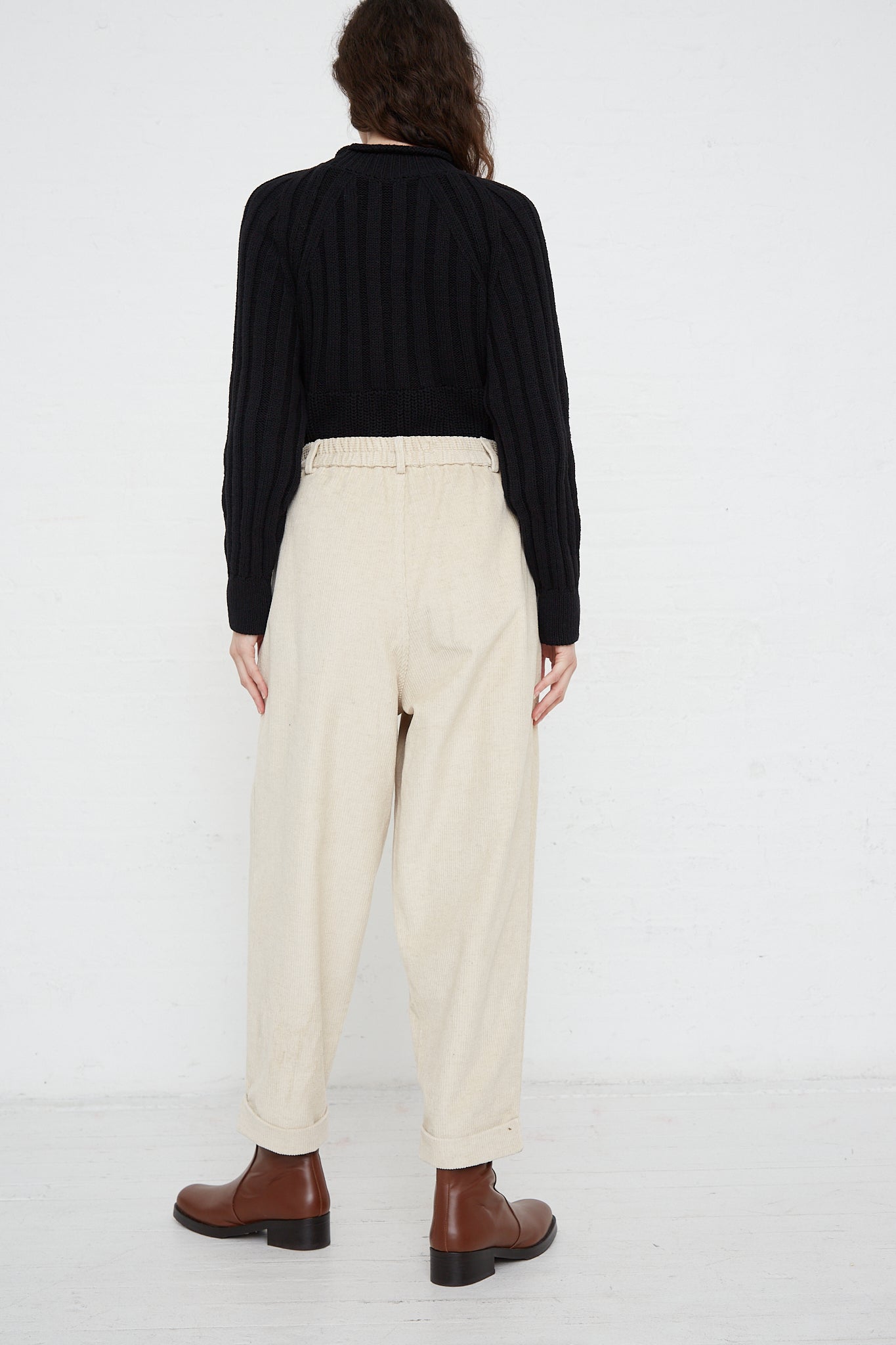 The back view of a woman wearing Corduroy Carrot Pants in Off White made by Cordera.