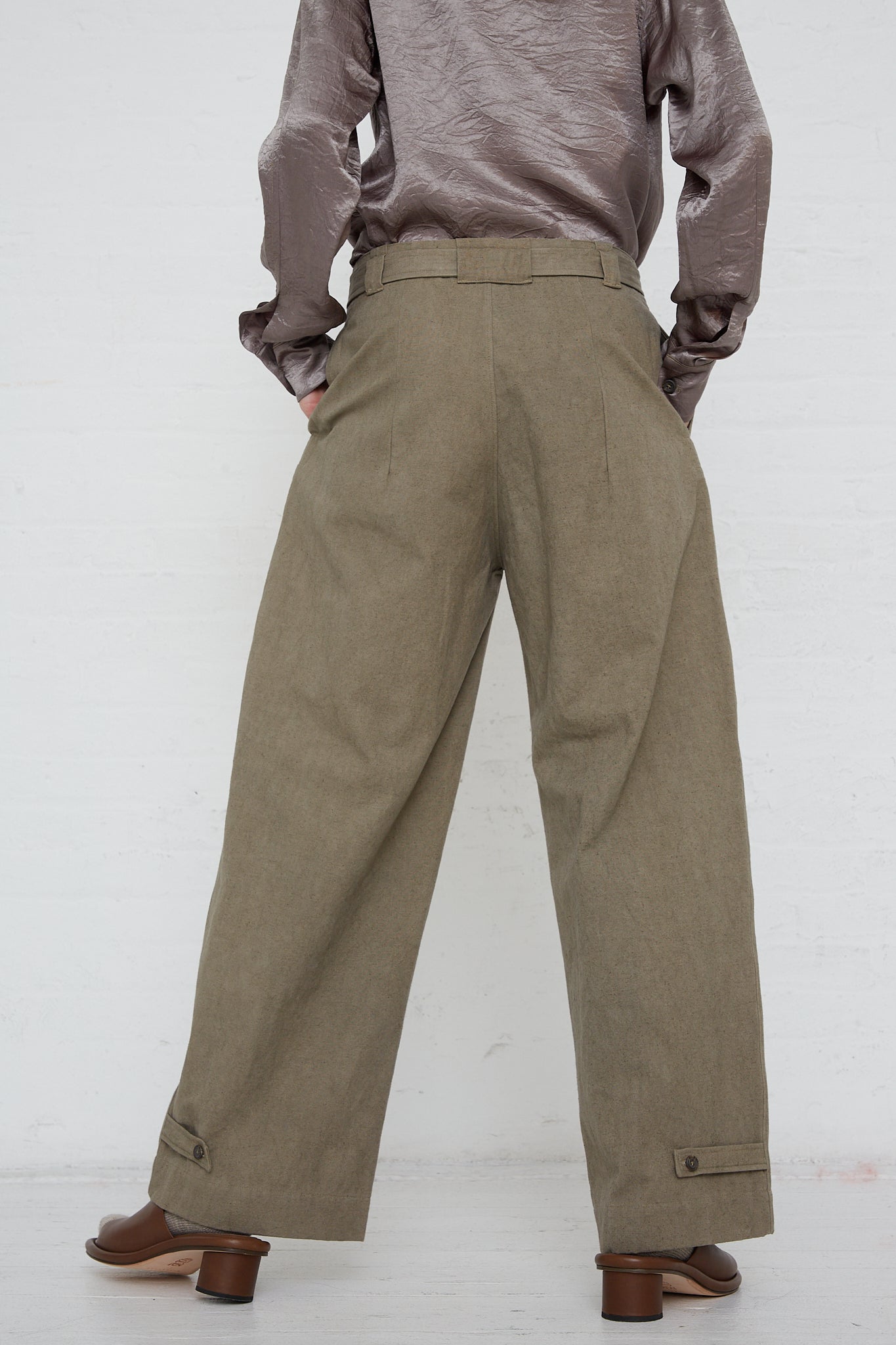 The back view of a woman wearing the Lauren Manoogian Belted Trouser in Fatigue, made from a cotton linen blend.