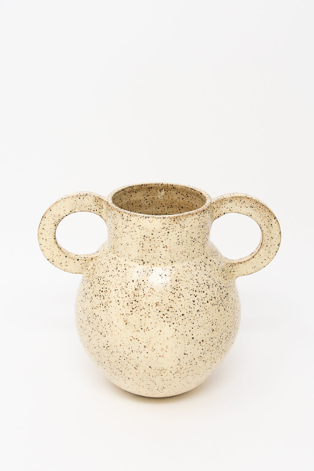 The "Arches in Sun Drop" from Lost Quarry is a speckled beige ceramic vase crafted from speckled clay, featuring two large round handles. It is showcased against a plain white background and is perfect for floral arrangements.